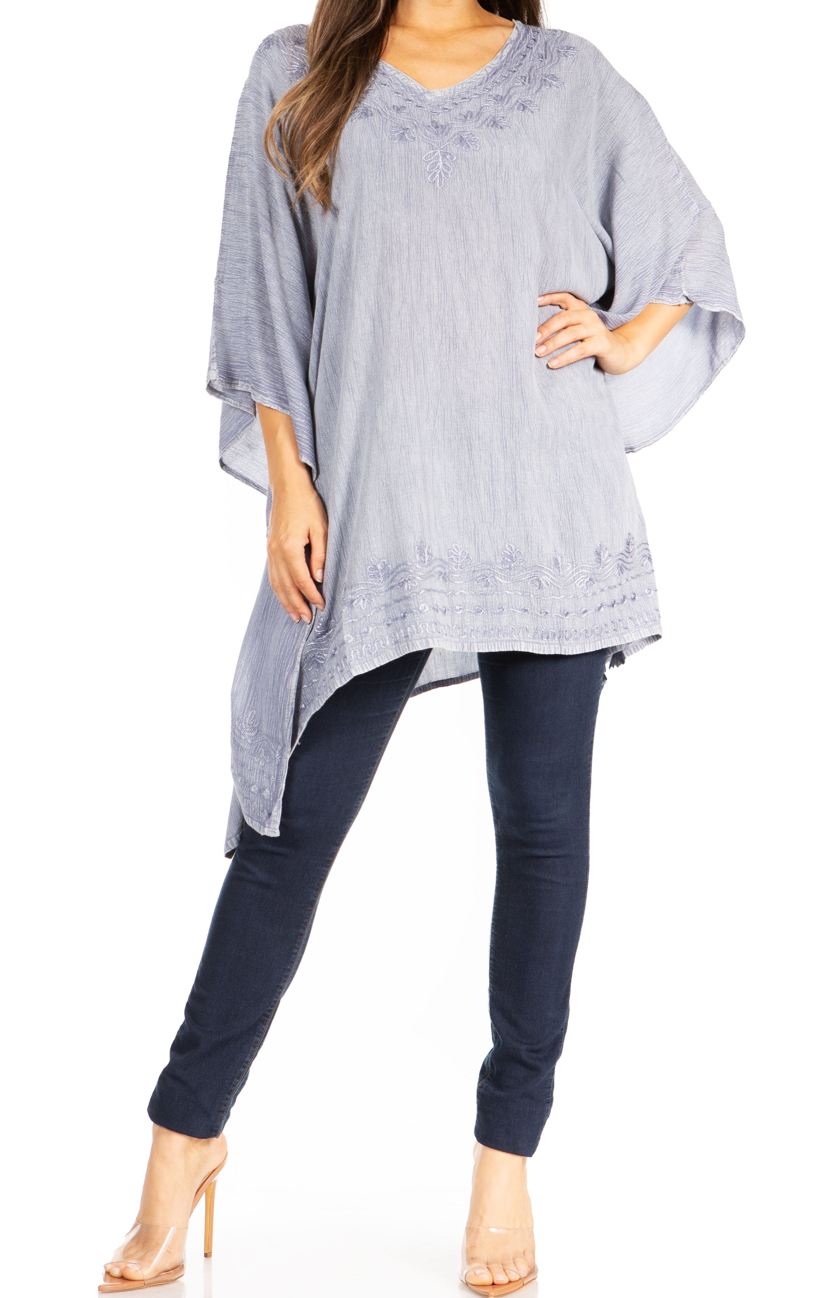 Woman wearing a light blue poncho over a dark blue outfit on a white background