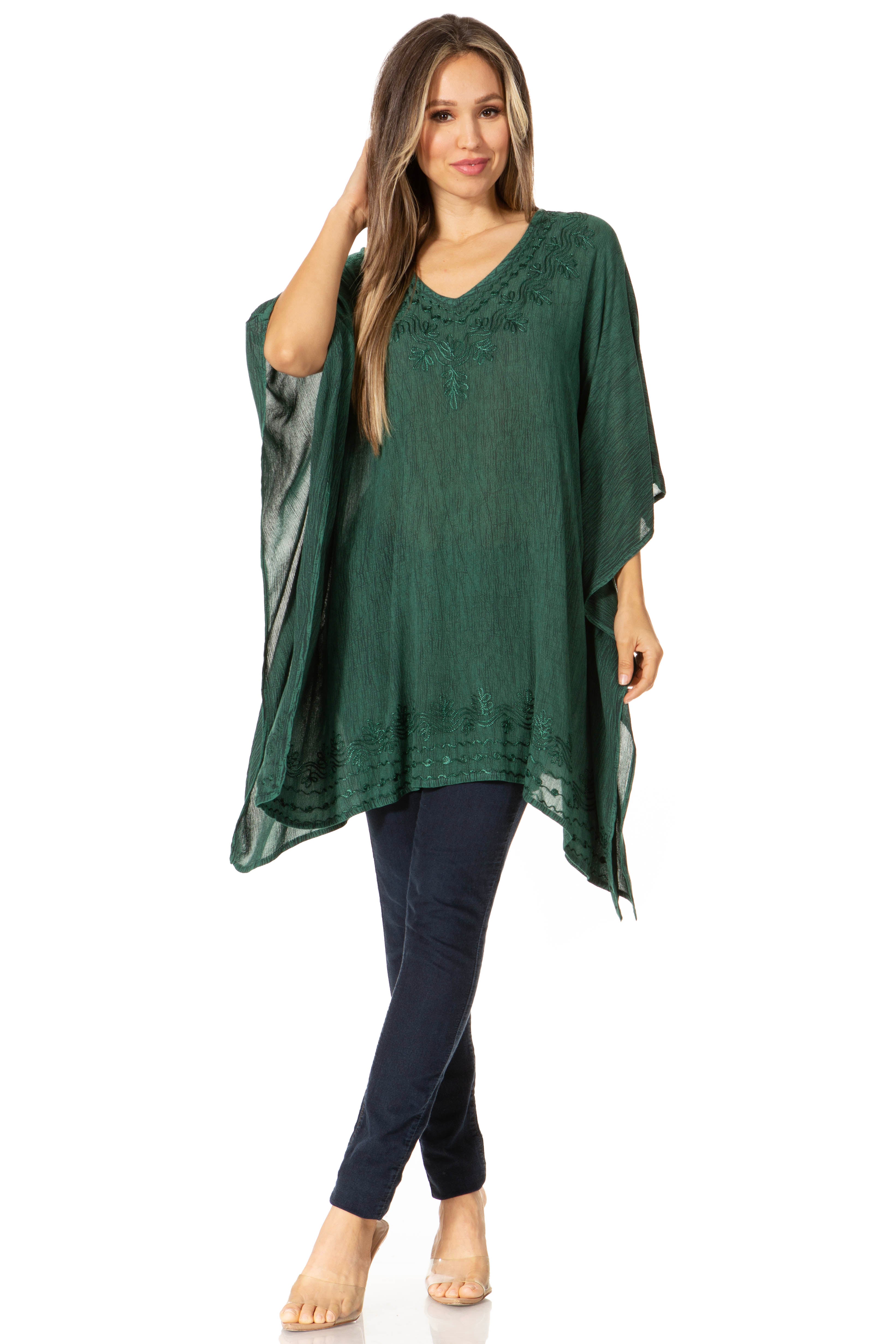 Woman wearing a green kaftan over a navy outfit on a white background