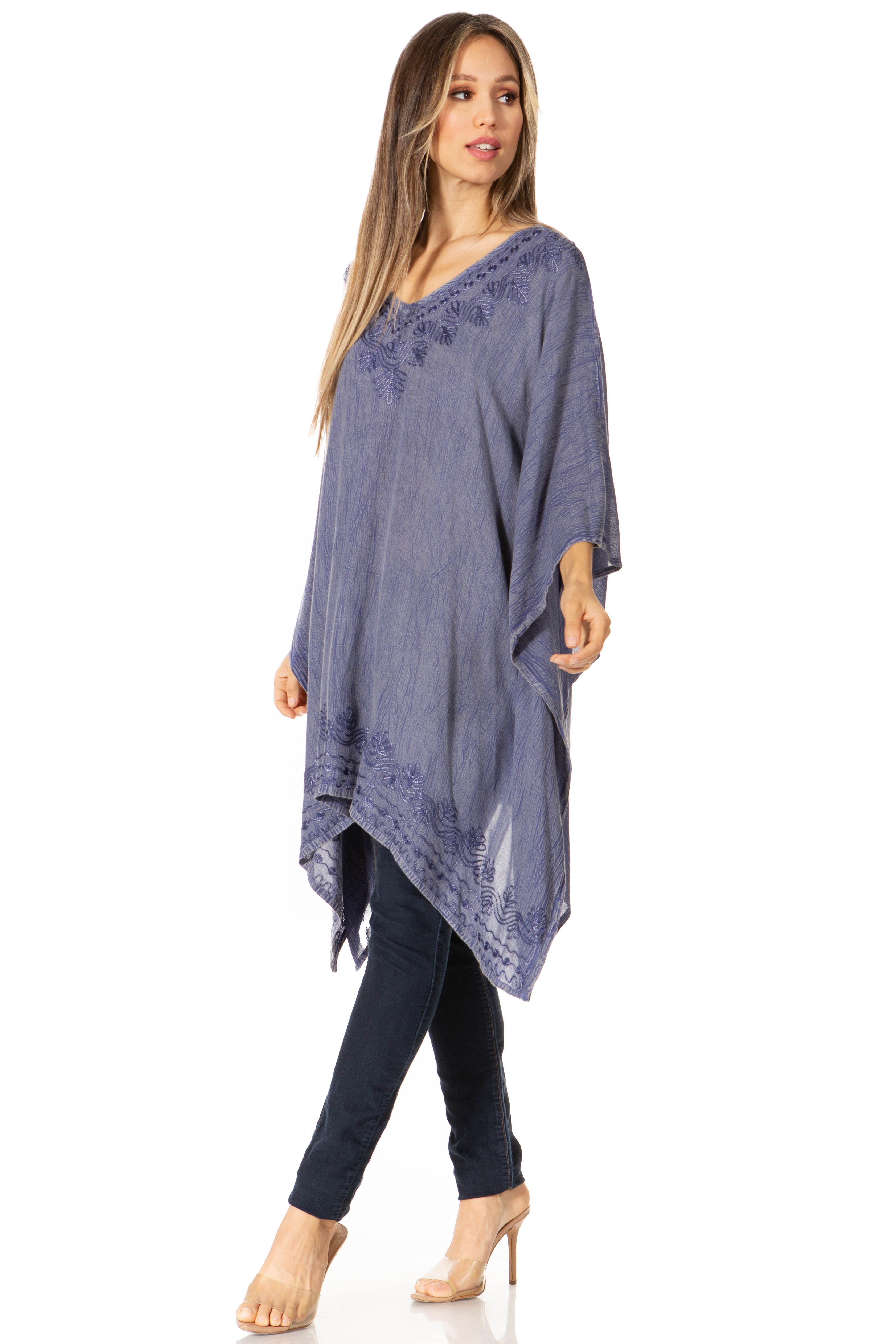 Woman wearing a blue poncho with embroidery on a white background