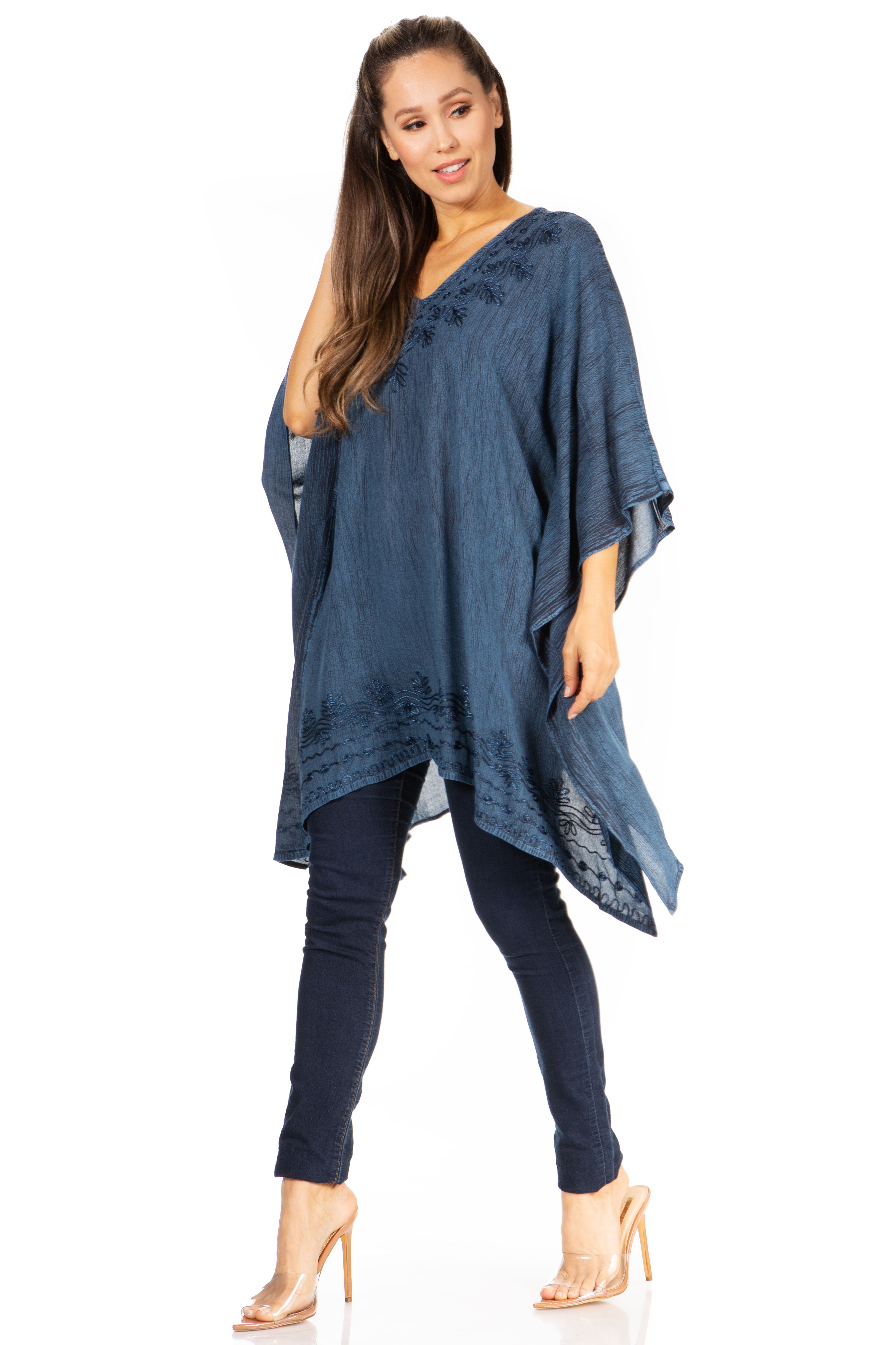 Woman wearing a blue poncho and pants on a white background