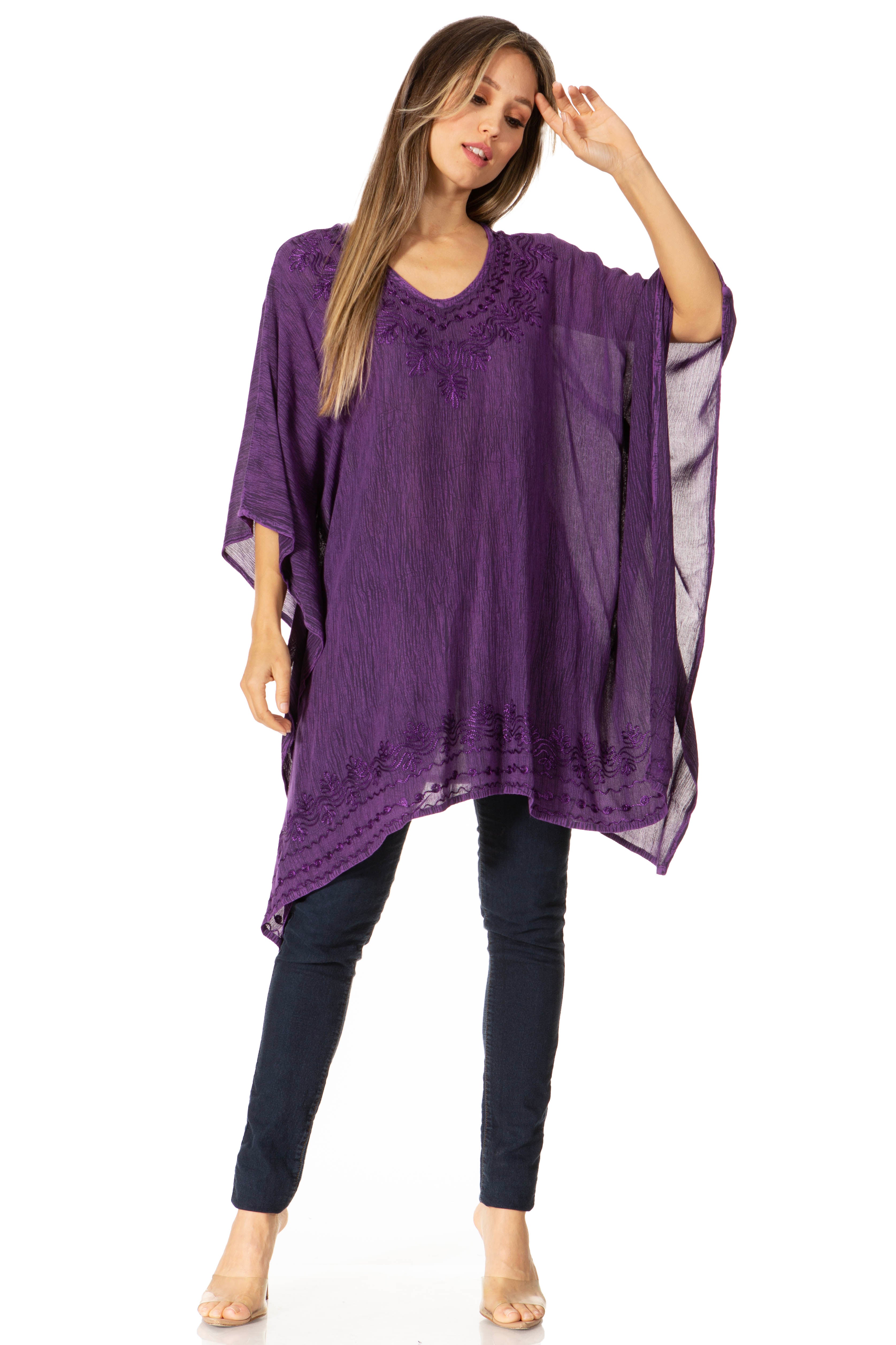 Woman wearing a purple kaftan over dark pants on a white background