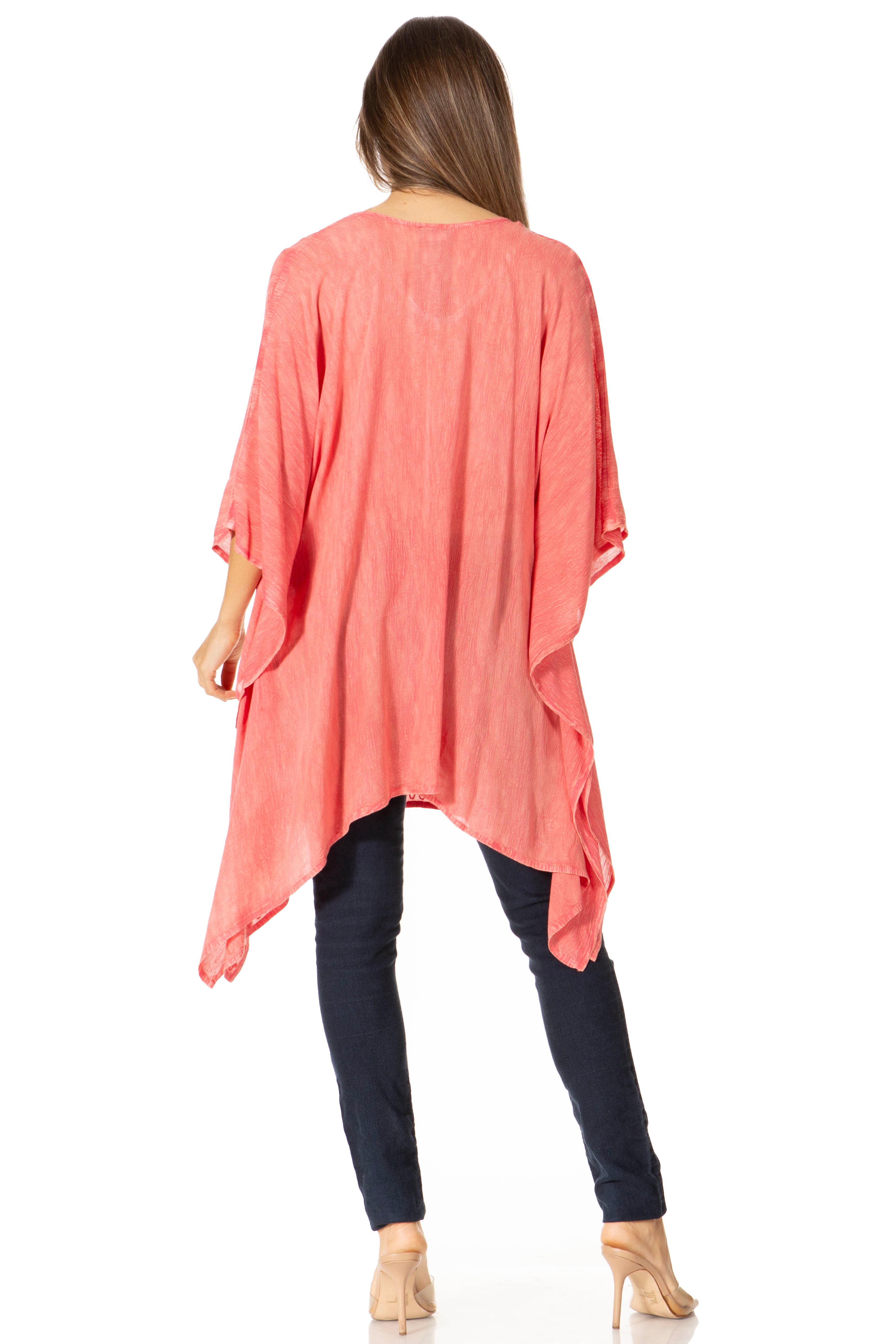 Woman wearing a coral oversized top and black pants on a white background