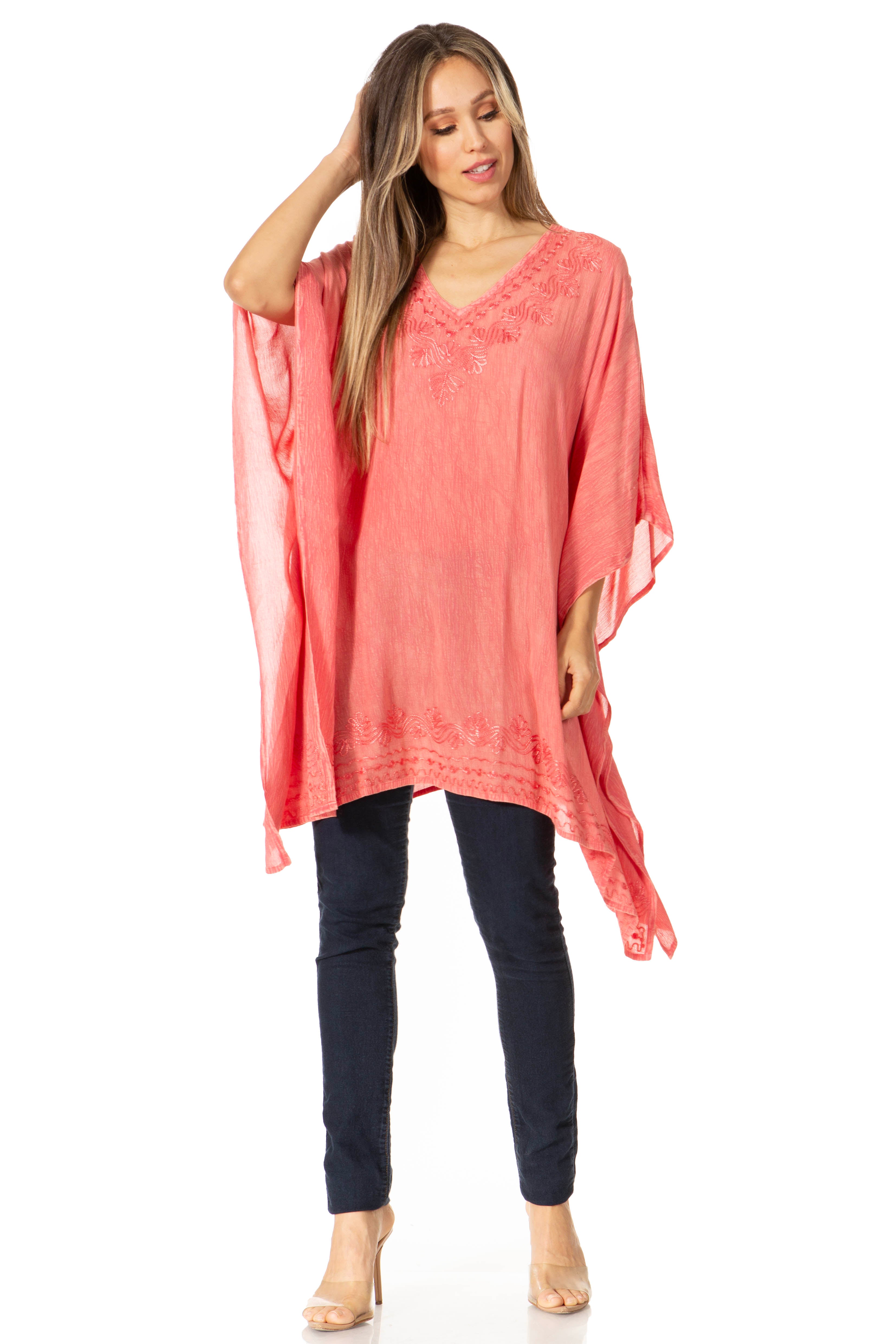 Woman wearing a coral tunic and dark pants on a white background