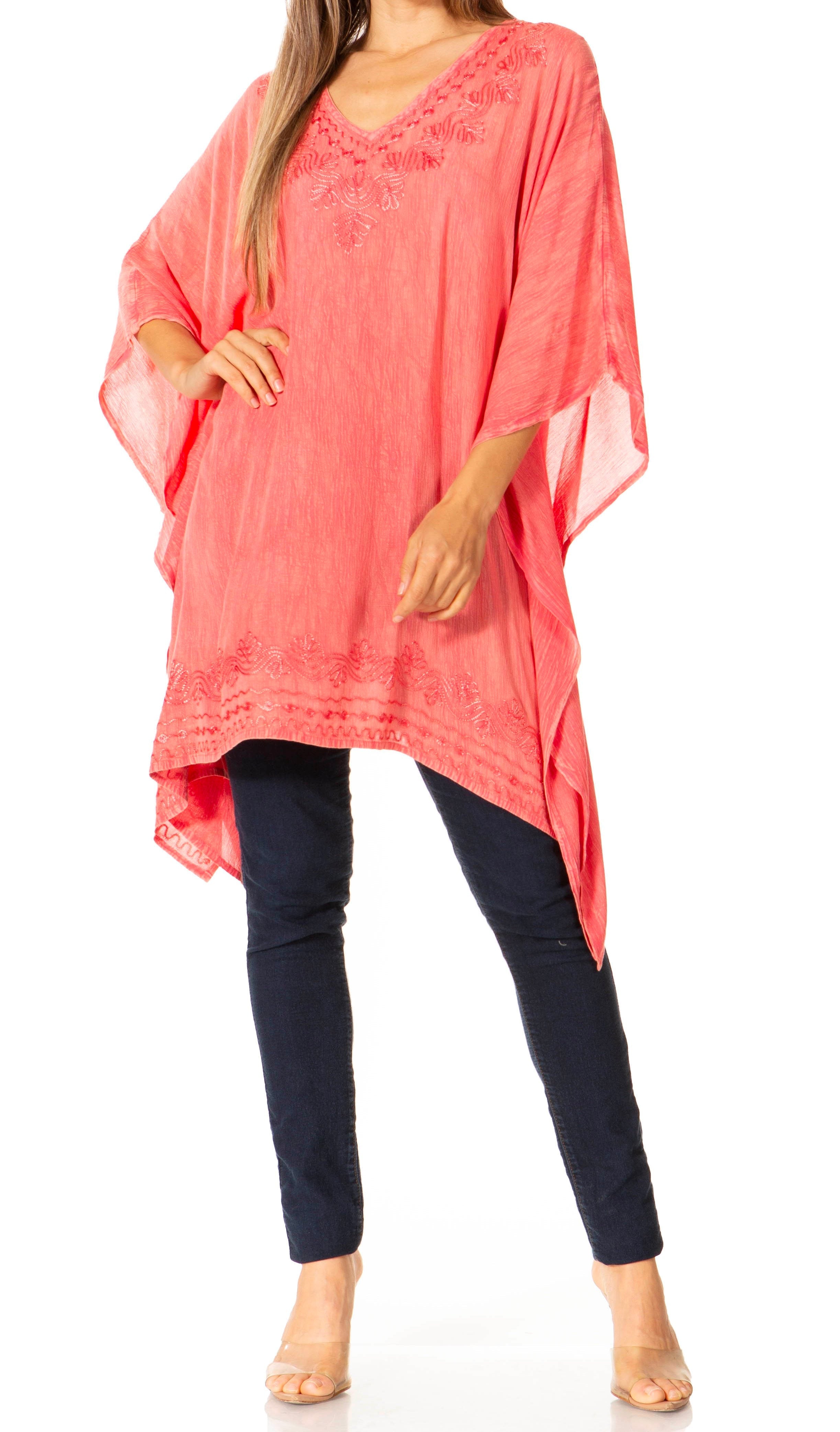 Woman wearing a coral cover-up and navy pants on a white background