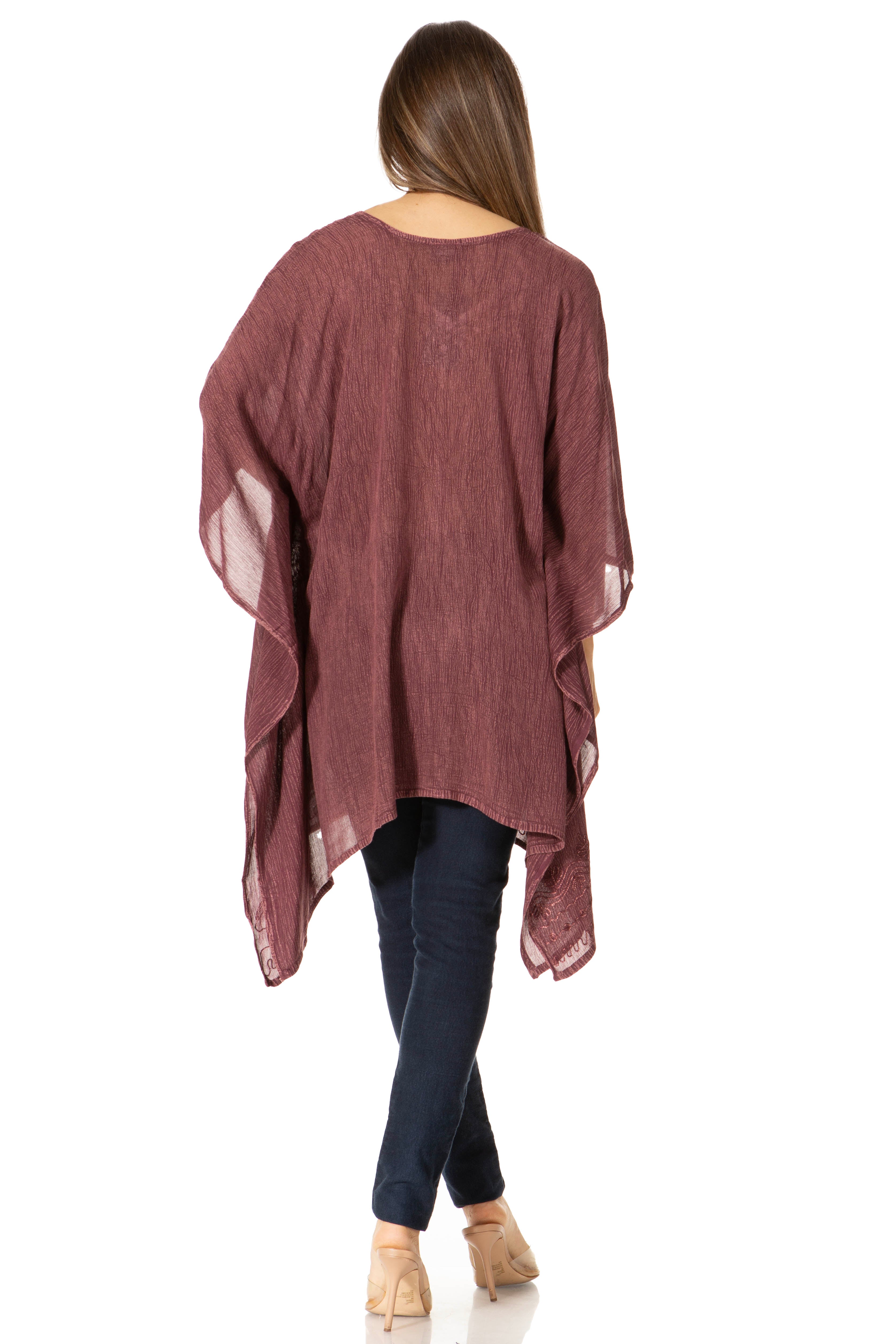 Woman wearing a burgundy kimono-style garment over dark jeans on a white background