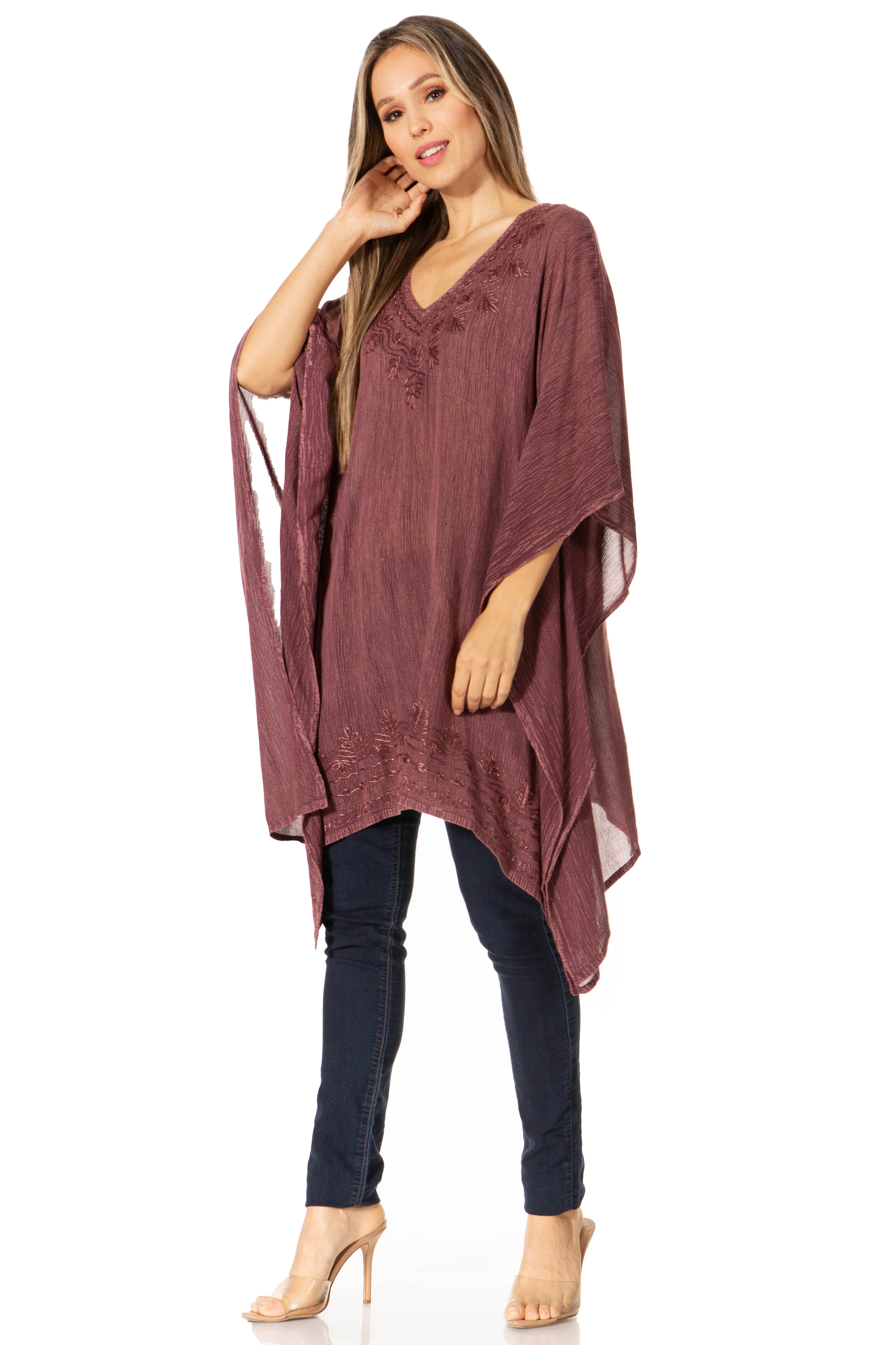 Woman wearing a burgundy poncho over a dark outfit on a white background