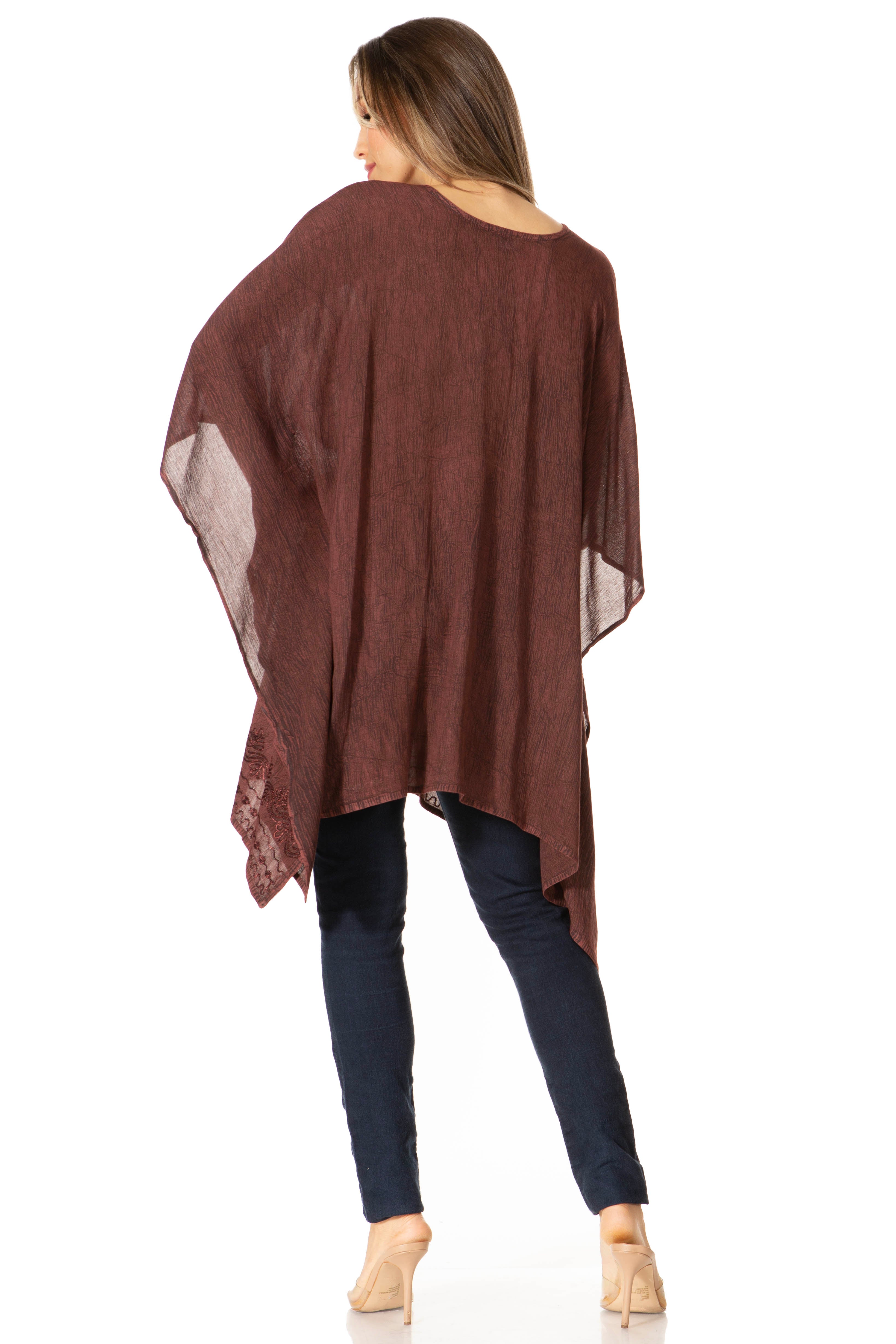 Woman wearing a brown poncho over a dark outfit on a white background