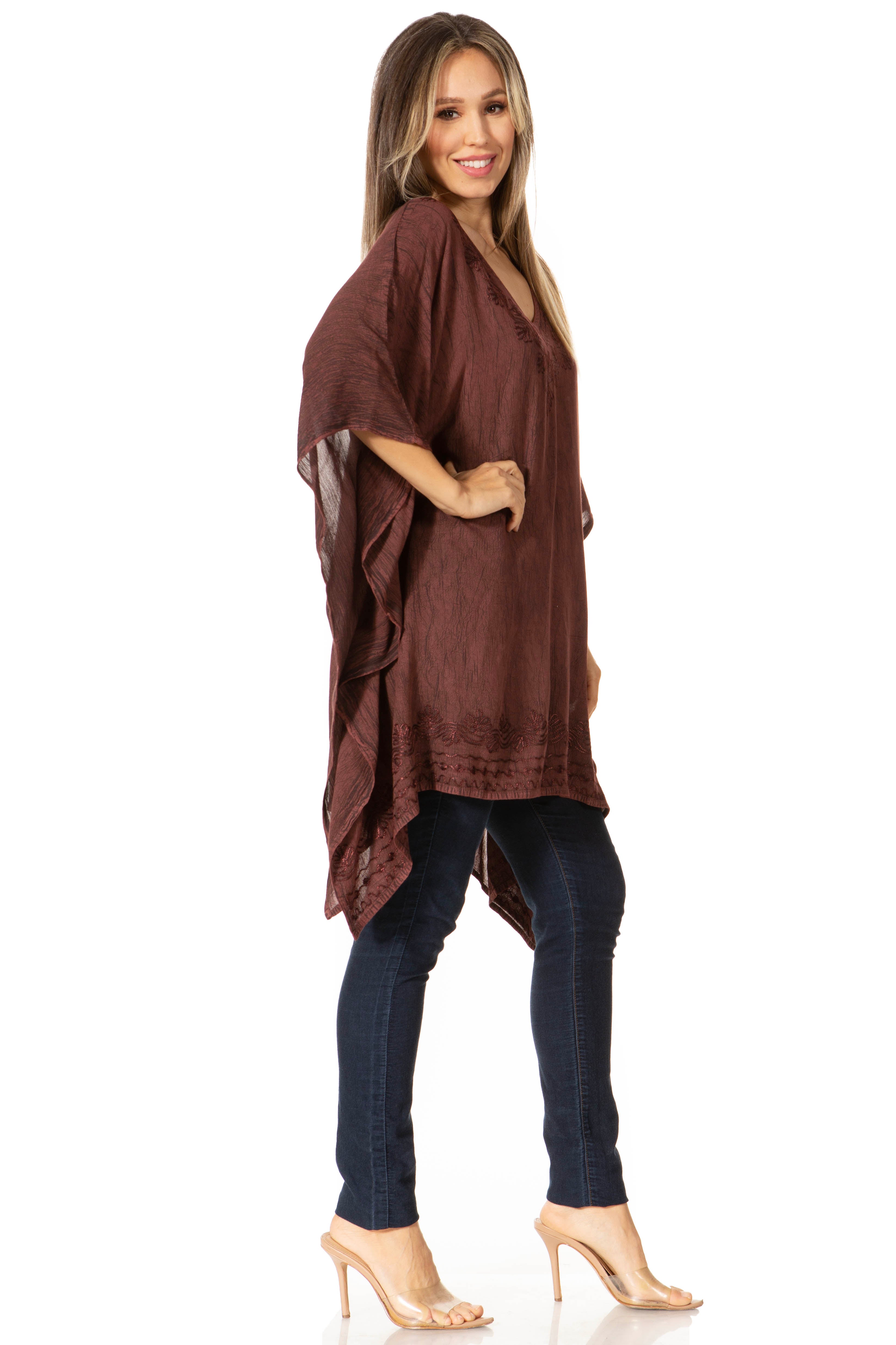Woman wearing a brown kimono-style top and dark jeans on a white background