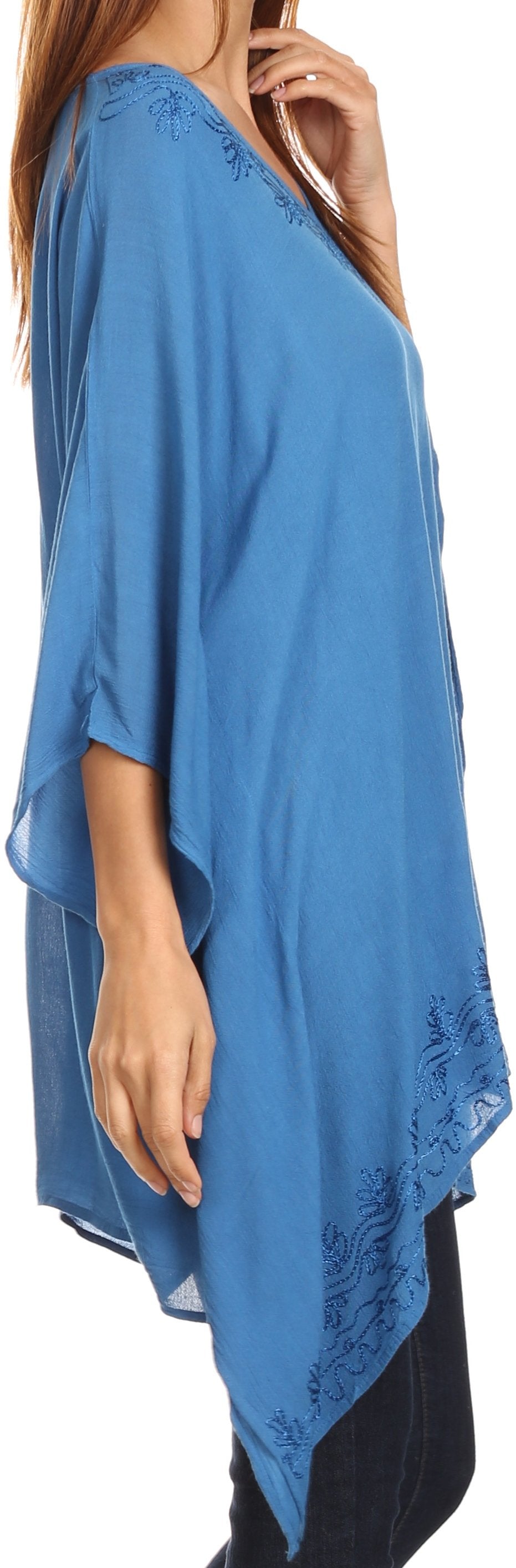Blue poncho with lace details worn by a person, on a plain background