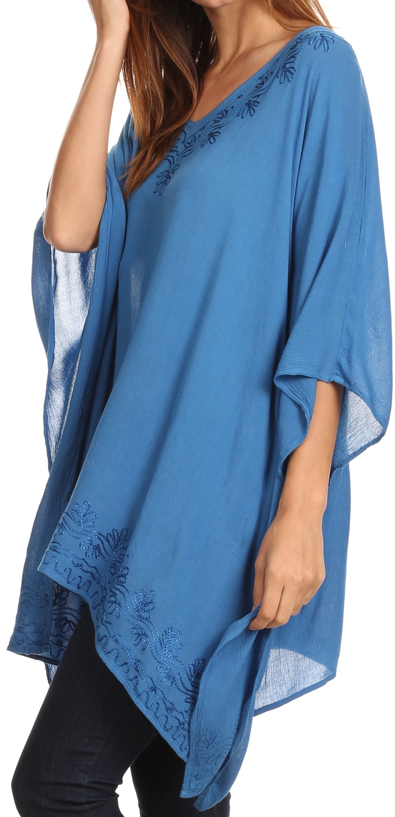 Blue poncho with lace details worn by a person on a white background