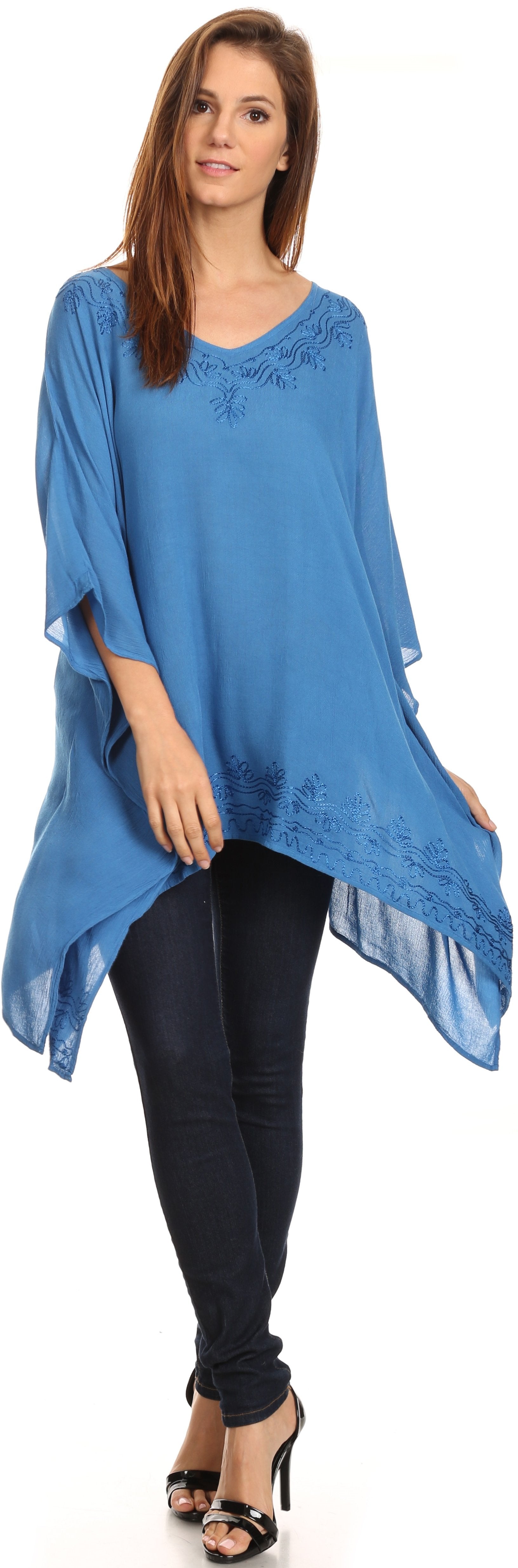 Woman wearing a blue poncho over a black outfit on a white background