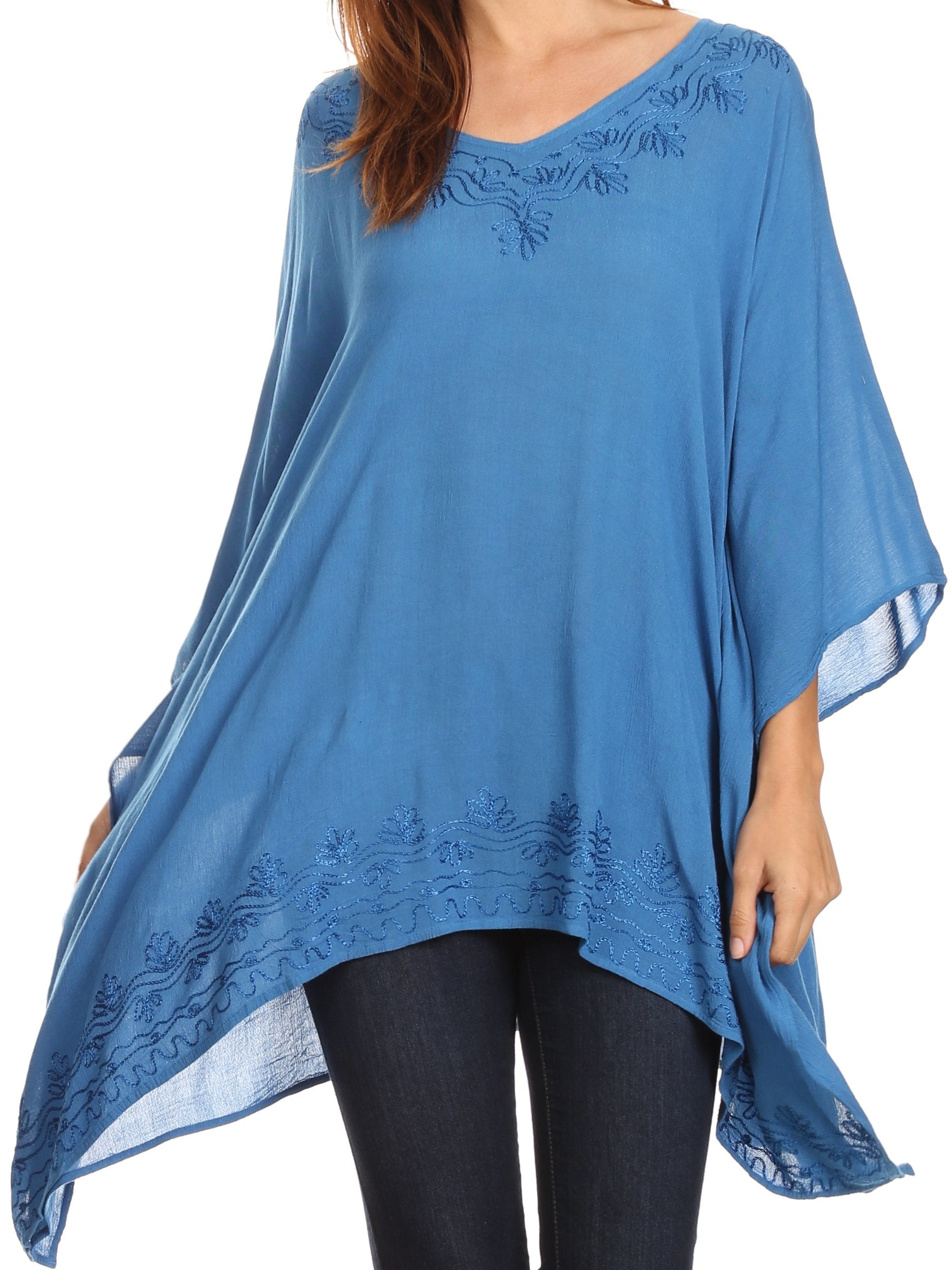 Blue poncho with floral embroidery worn by a person on a white background