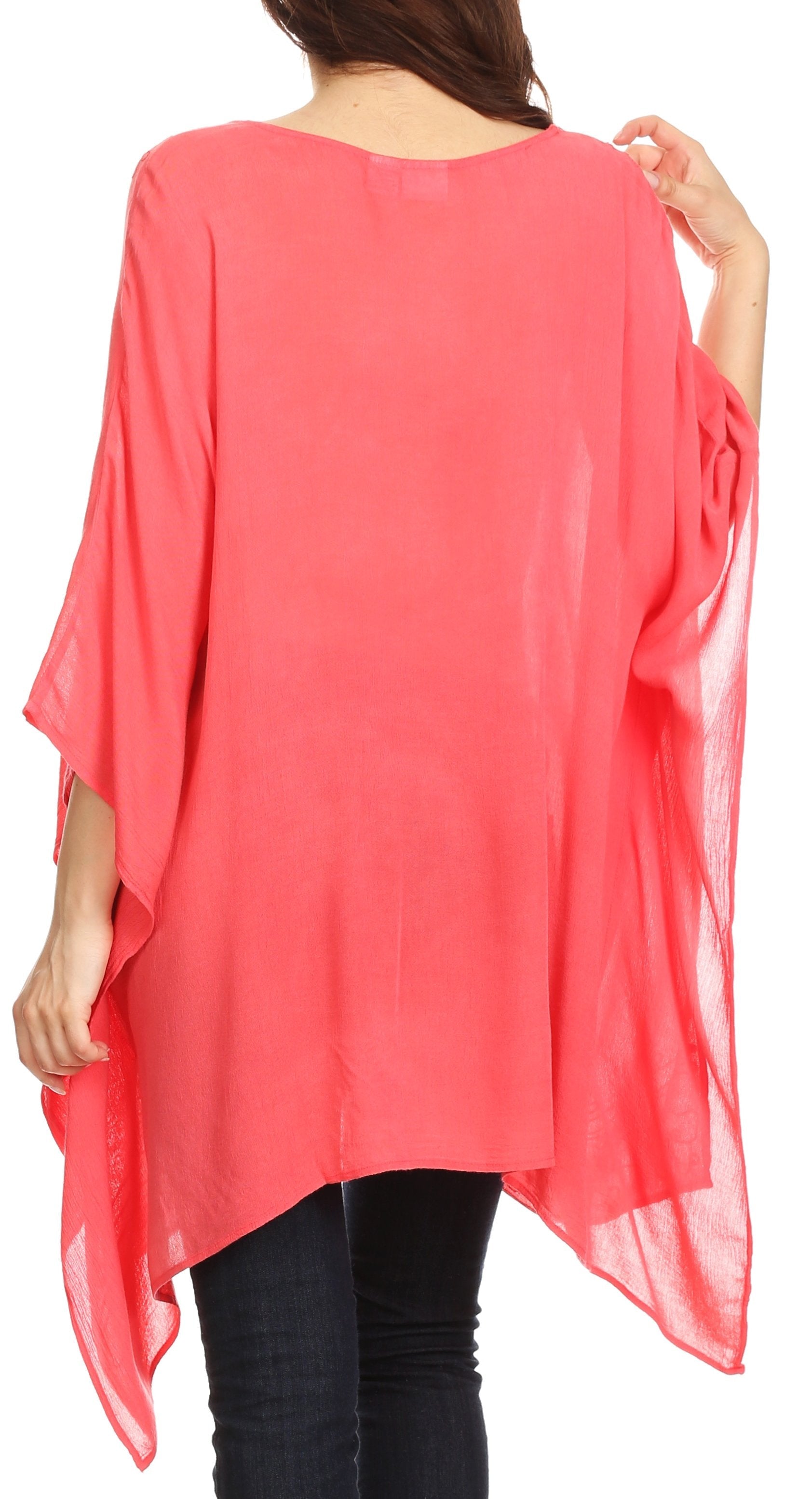 Coral pink poncho being worn by a person on a white background