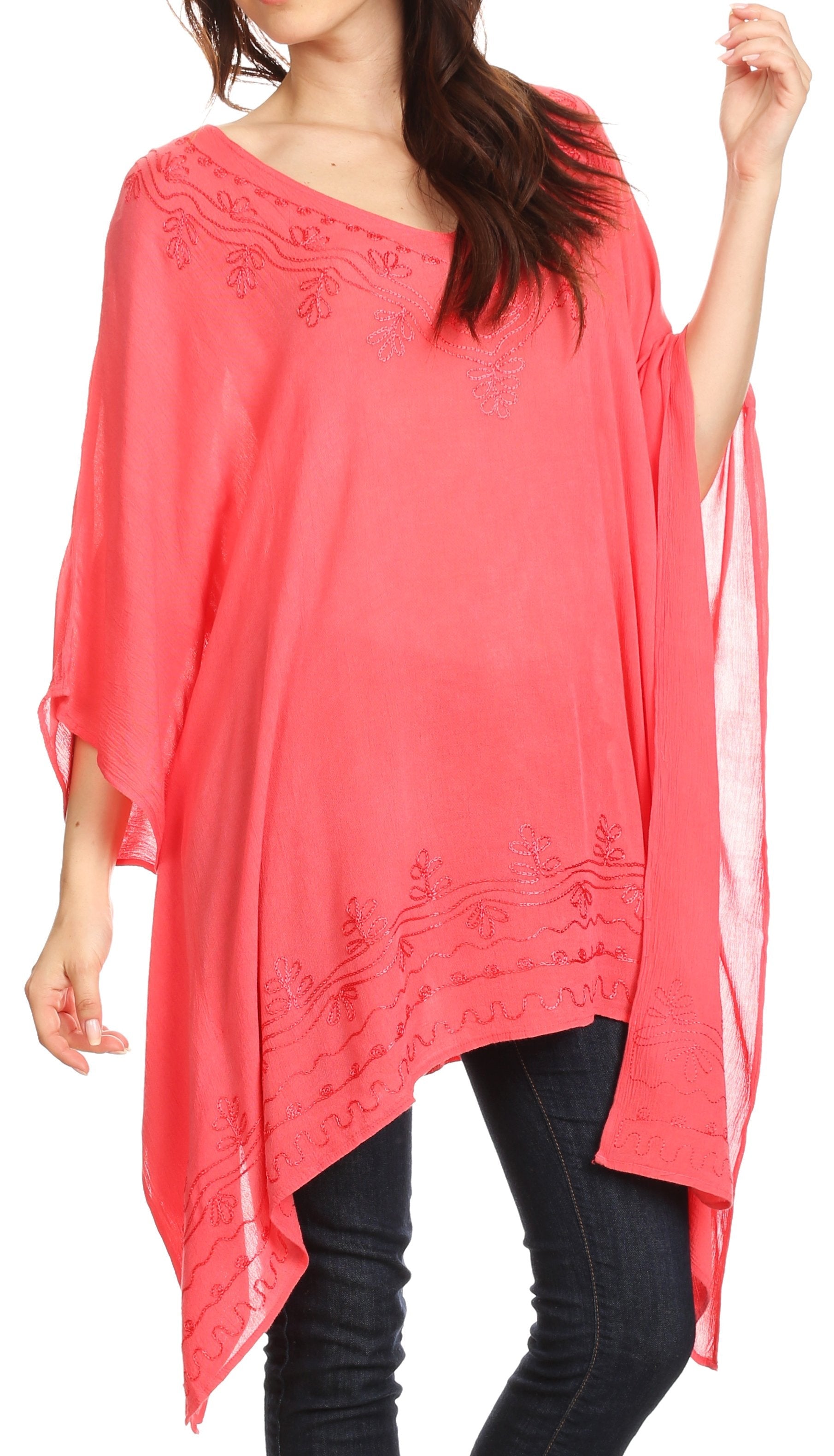 Coral poncho with floral embroidery worn by a person on a white background