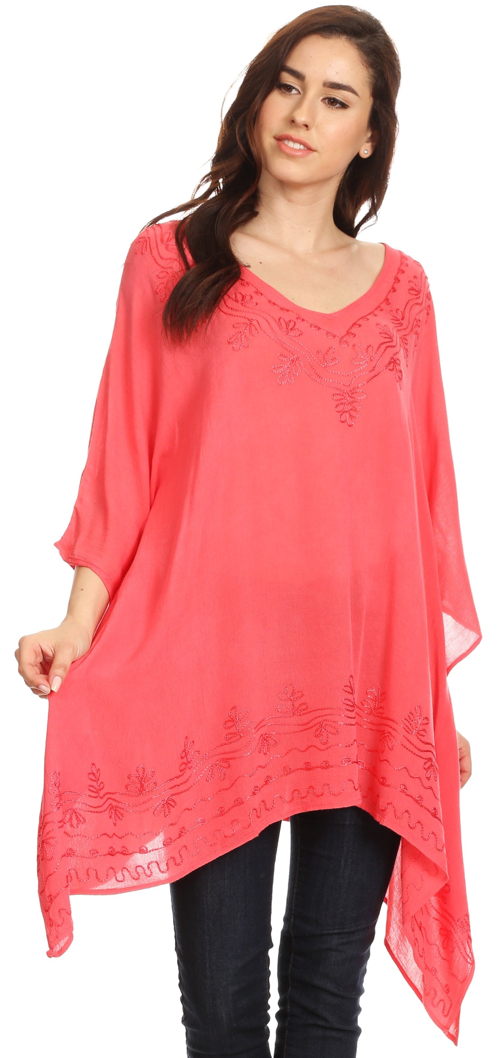 Woman wearing a coral pink embroidered top on a white background