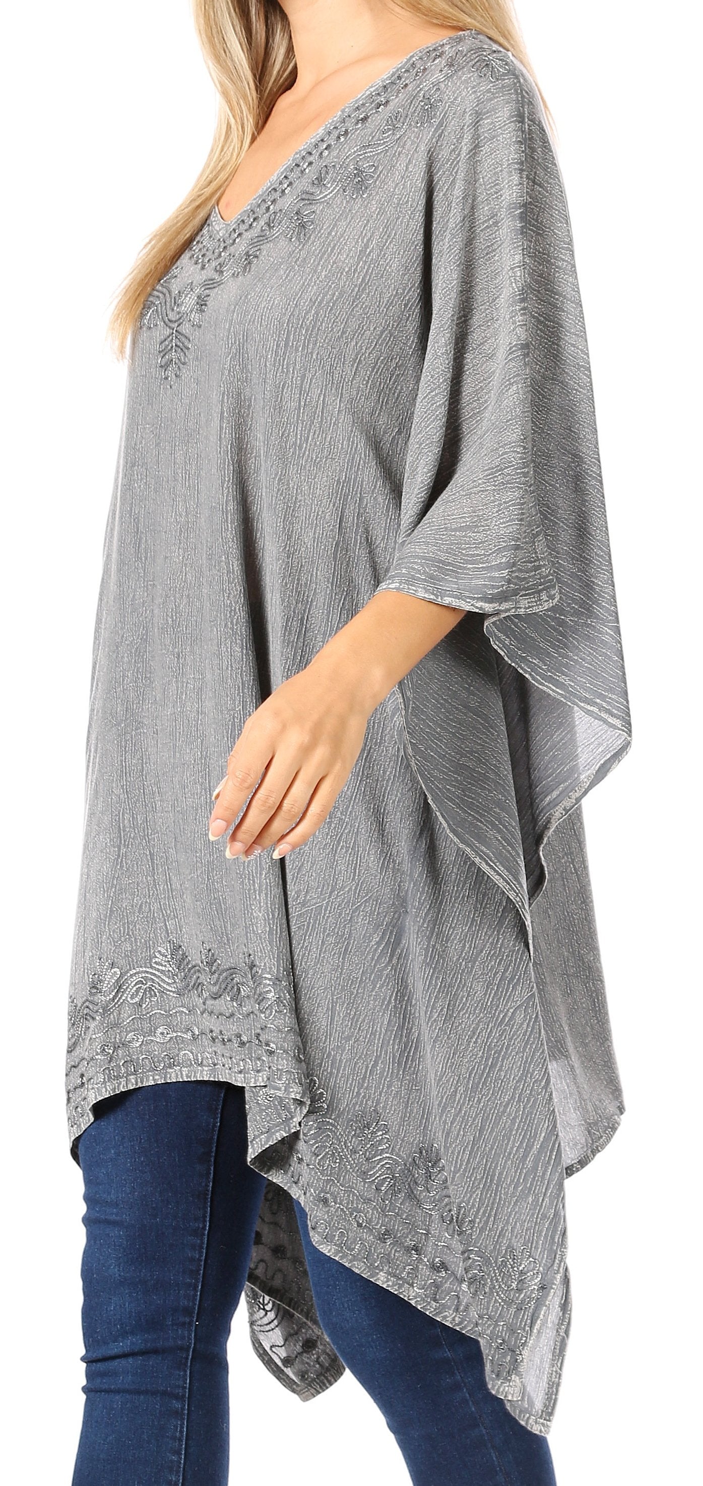 Woman wearing a gray poncho with lace details on a white background