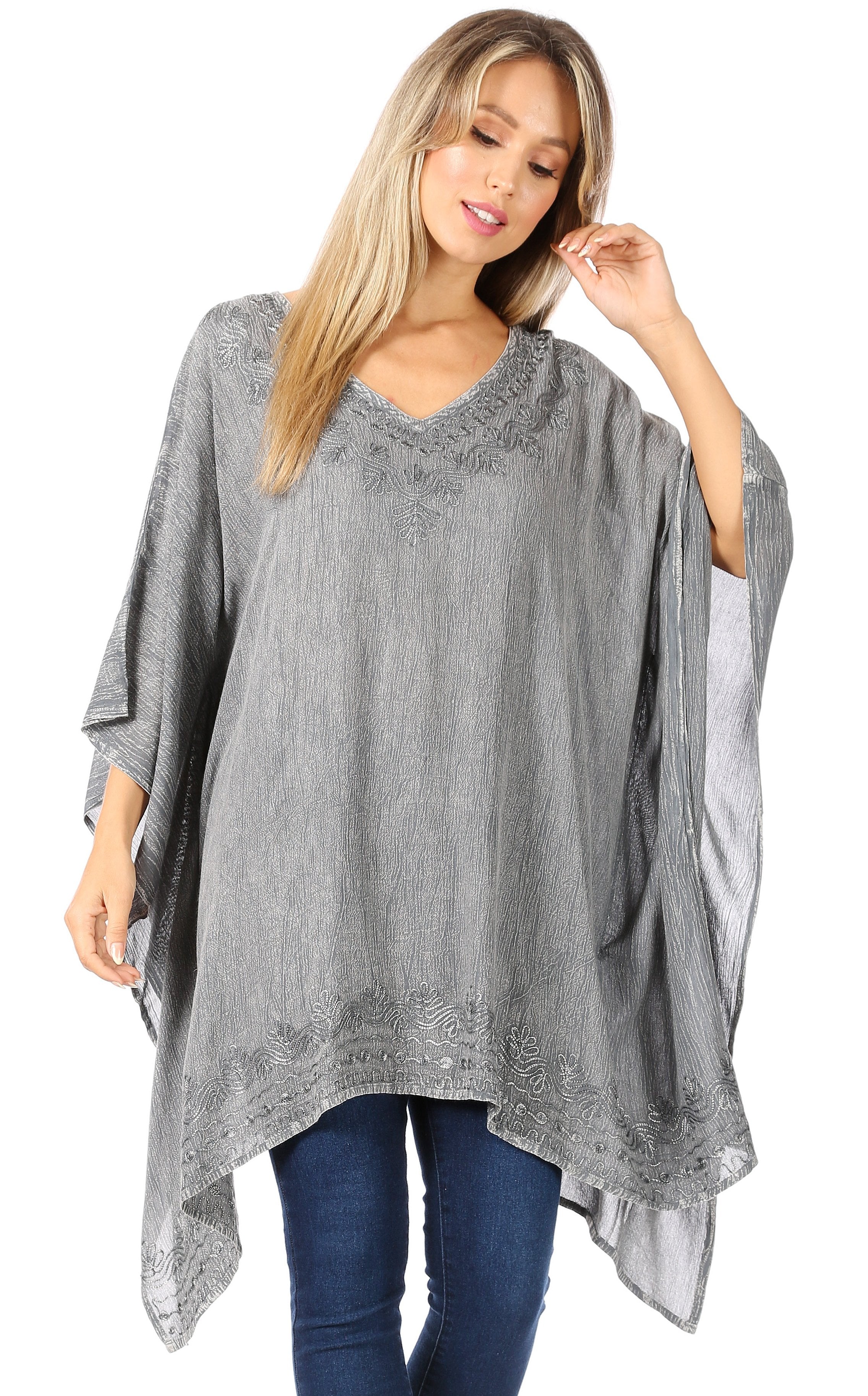 Woman wearing a gray poncho with lace details on a white background