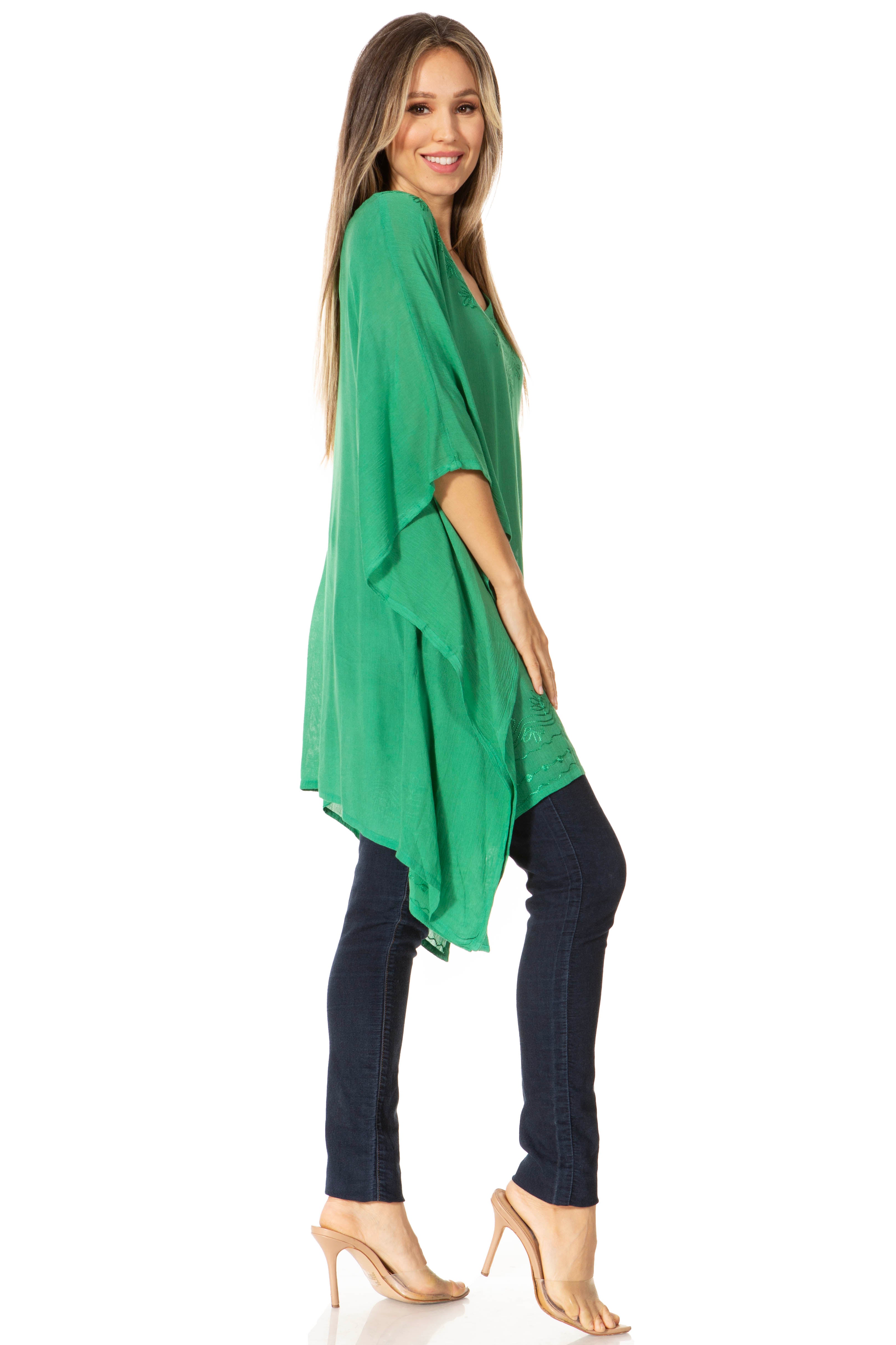 Woman wearing a green oversized top and dark pants on a white background