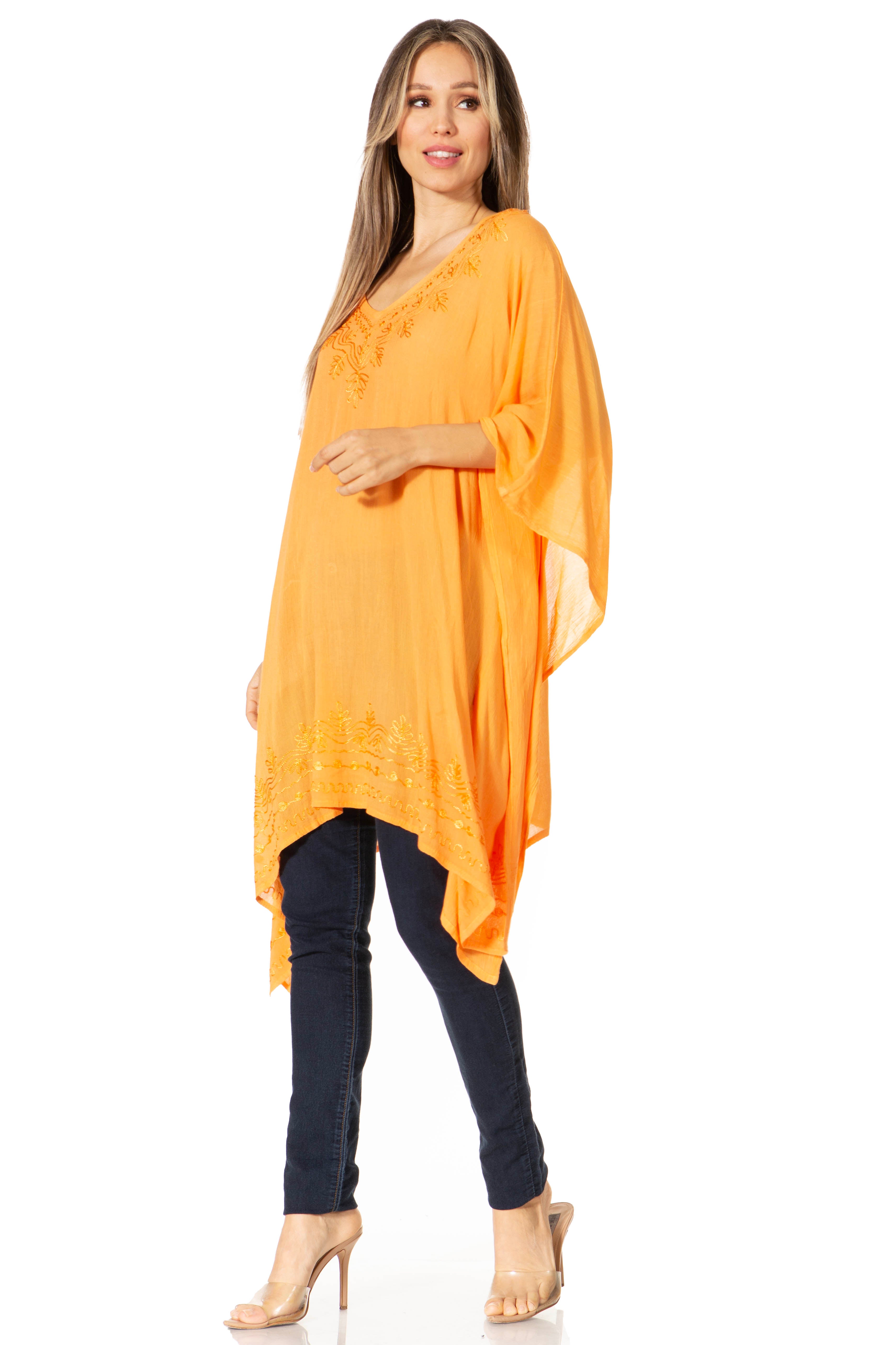 Woman wearing an orange poncho over a black outfit on a white background