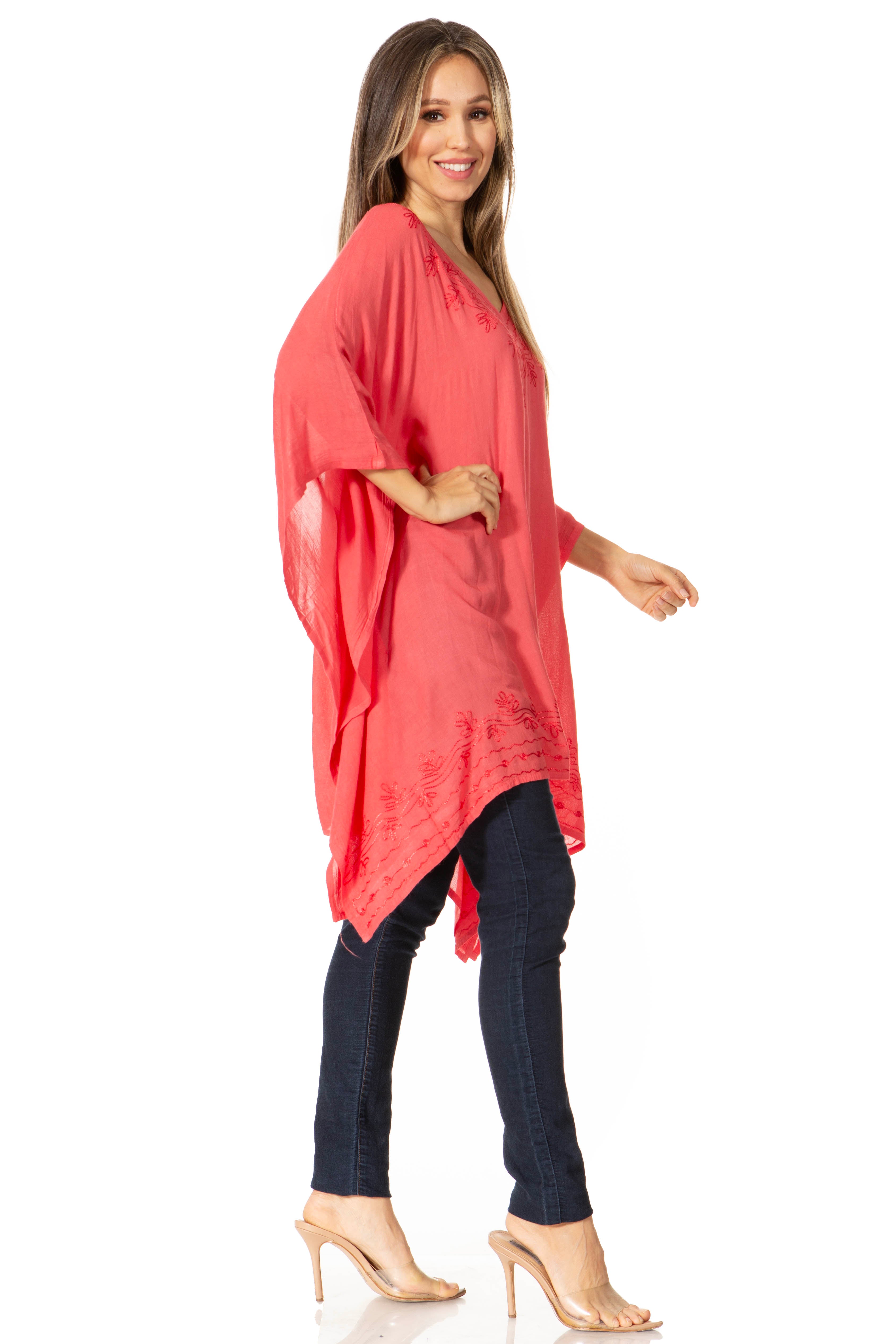 Woman wearing a coral kimono-style garment over dark pants on a white background