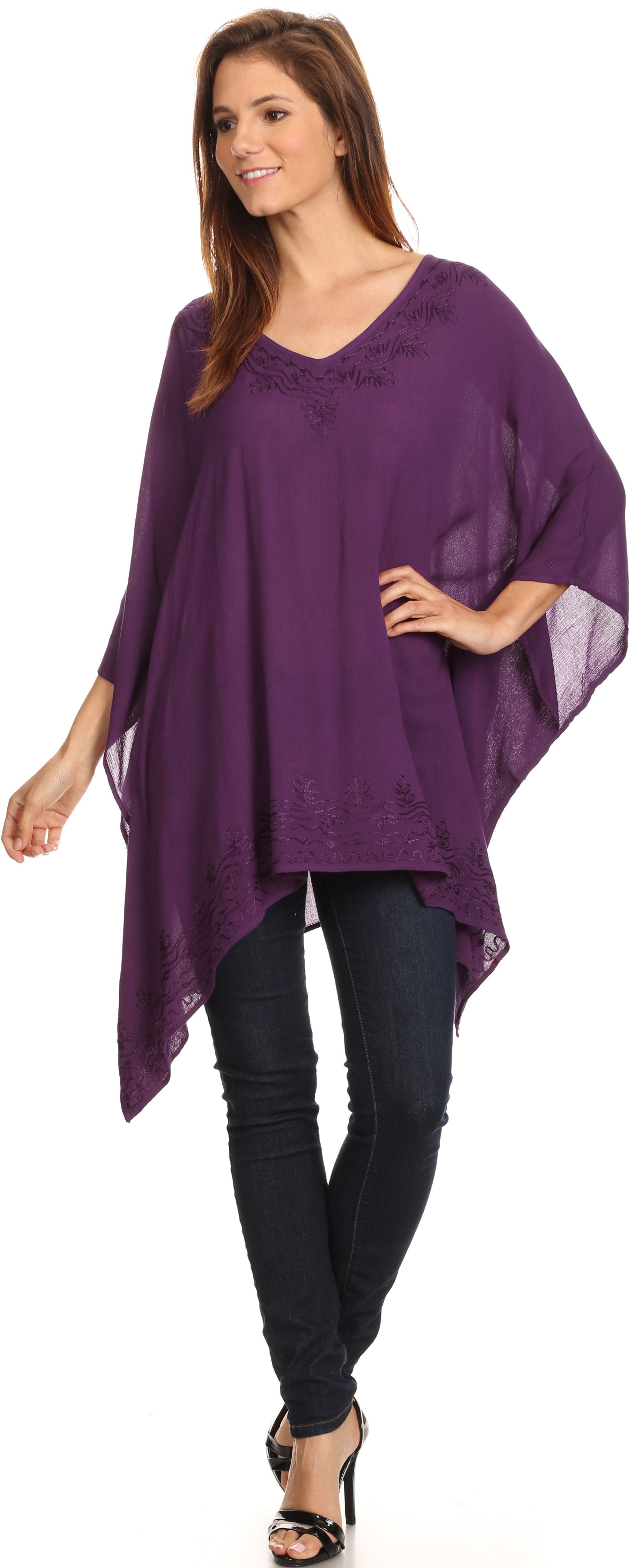 Woman wearing a purple poncho over a black outfit on a white background