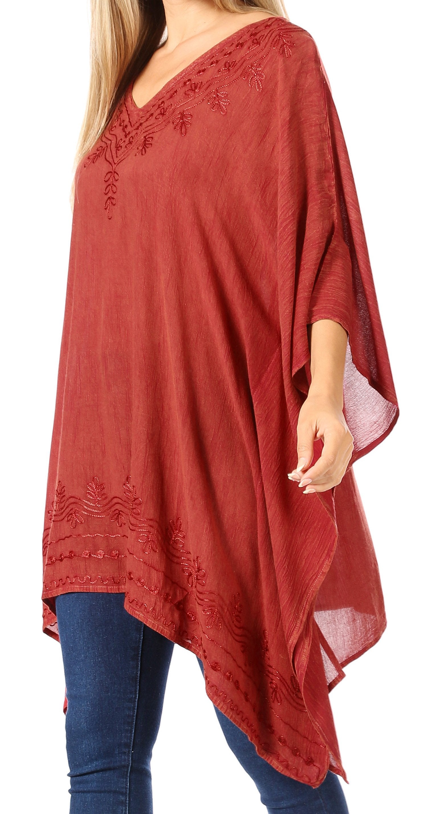 Red poncho with embroidery worn by a person on a white background