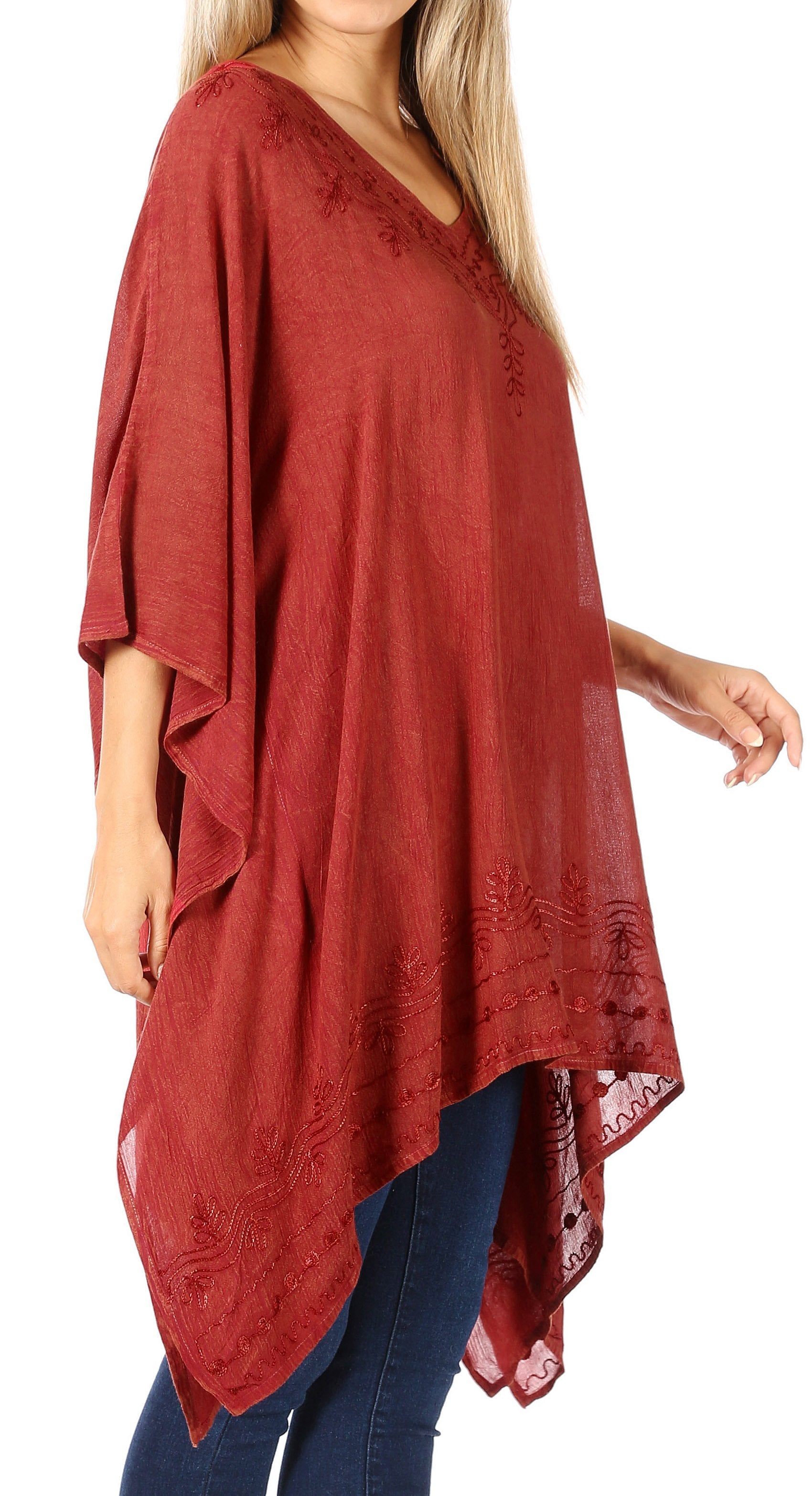 Red poncho with lace details worn by a person on a white background