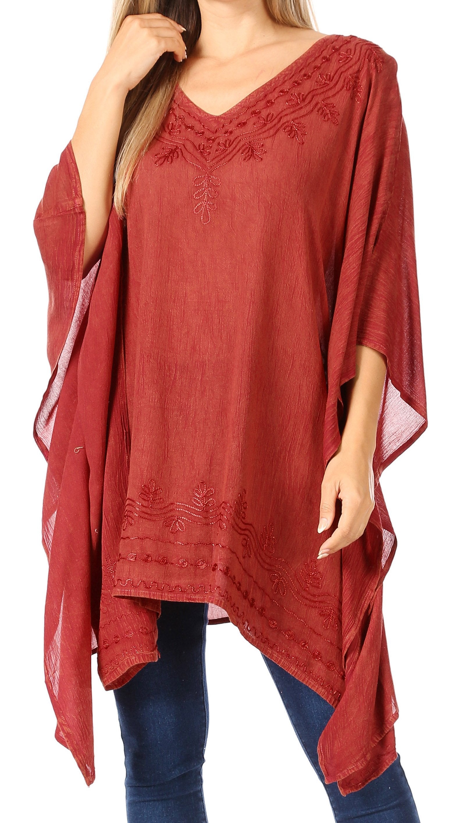 Red poncho with lace details worn by a person on a white background