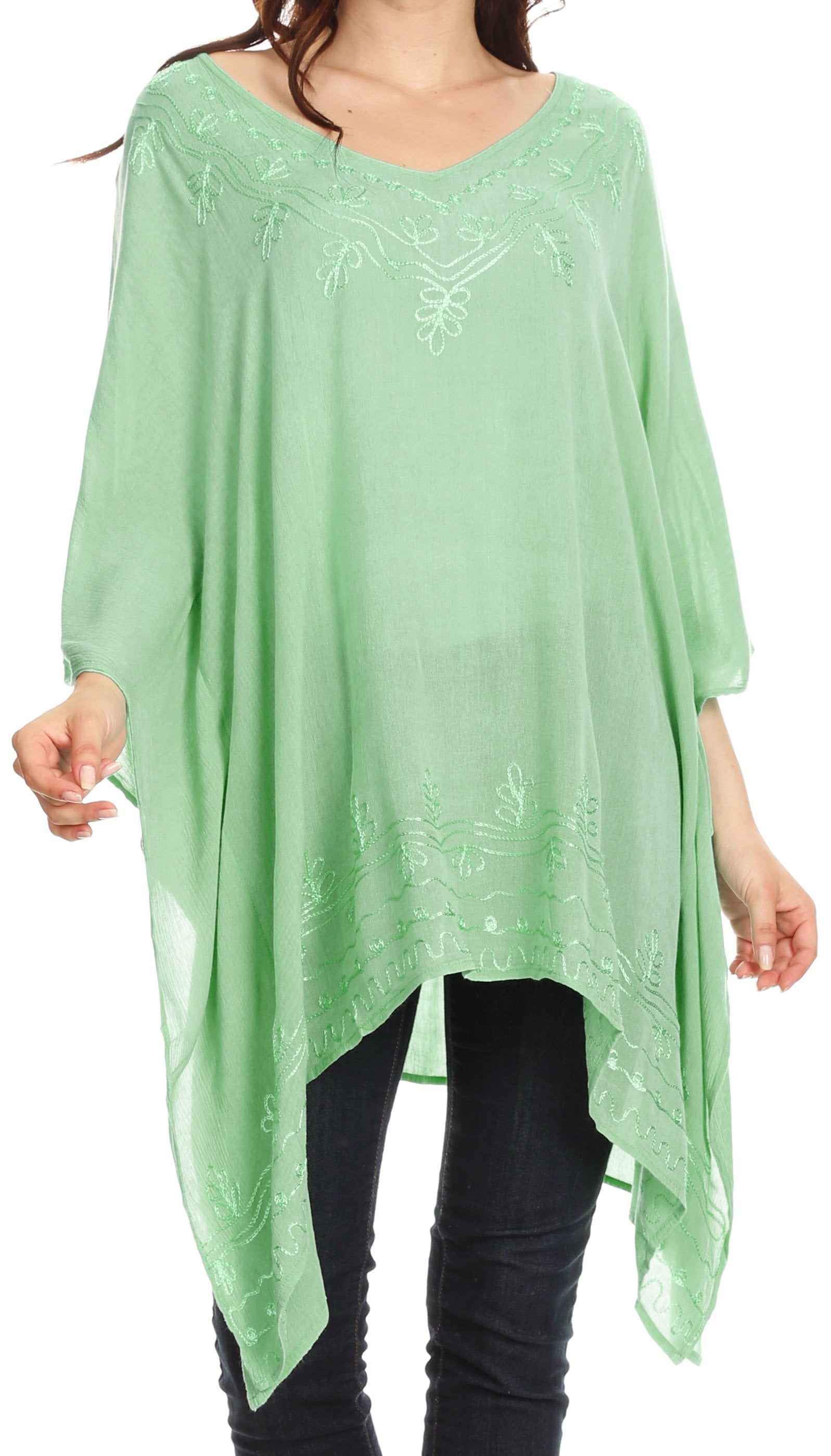 Green poncho with embroidery worn by a person on a white background