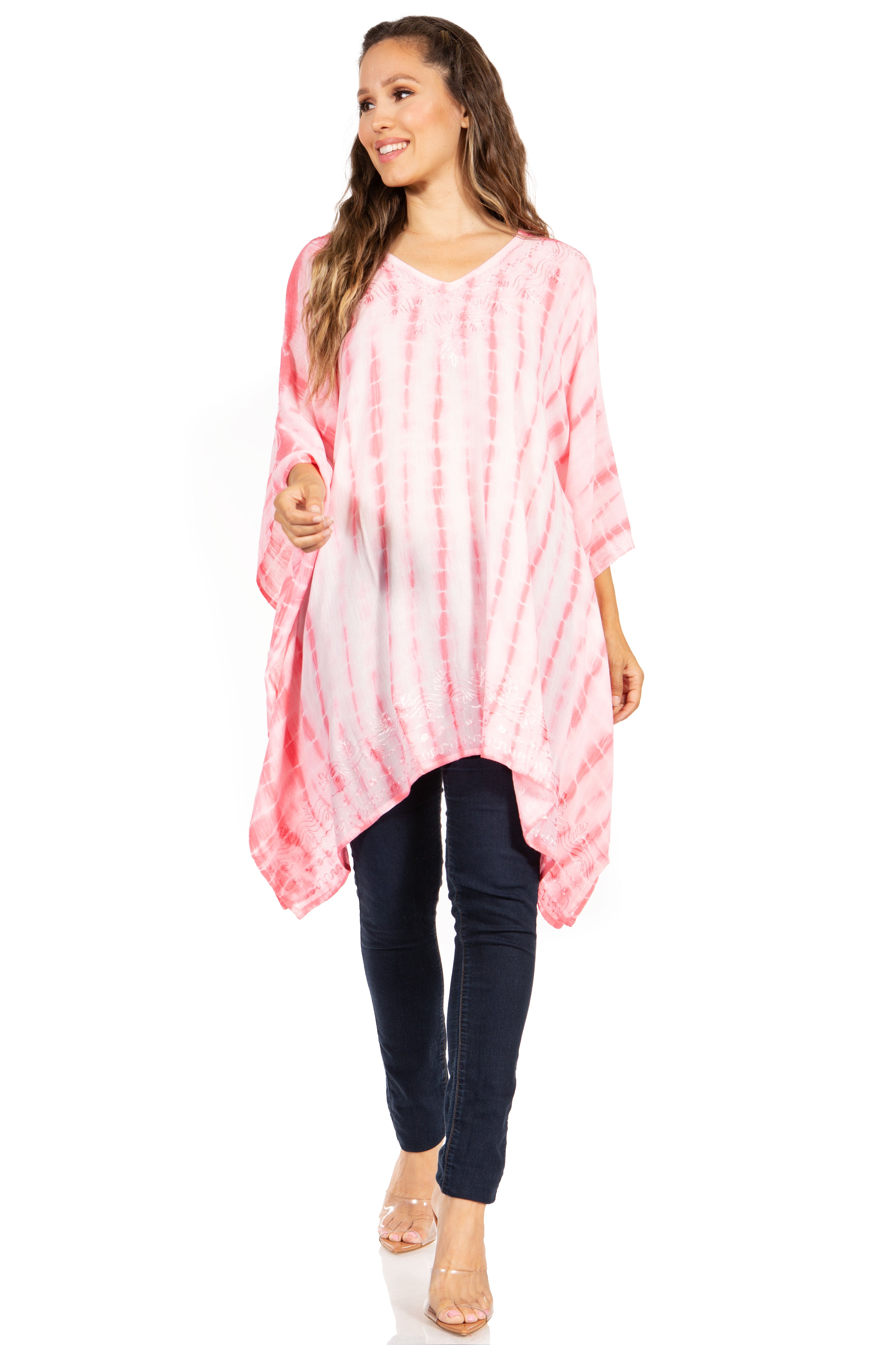 Woman wearing a pink tie-dye shirt and dark jeans on a white background