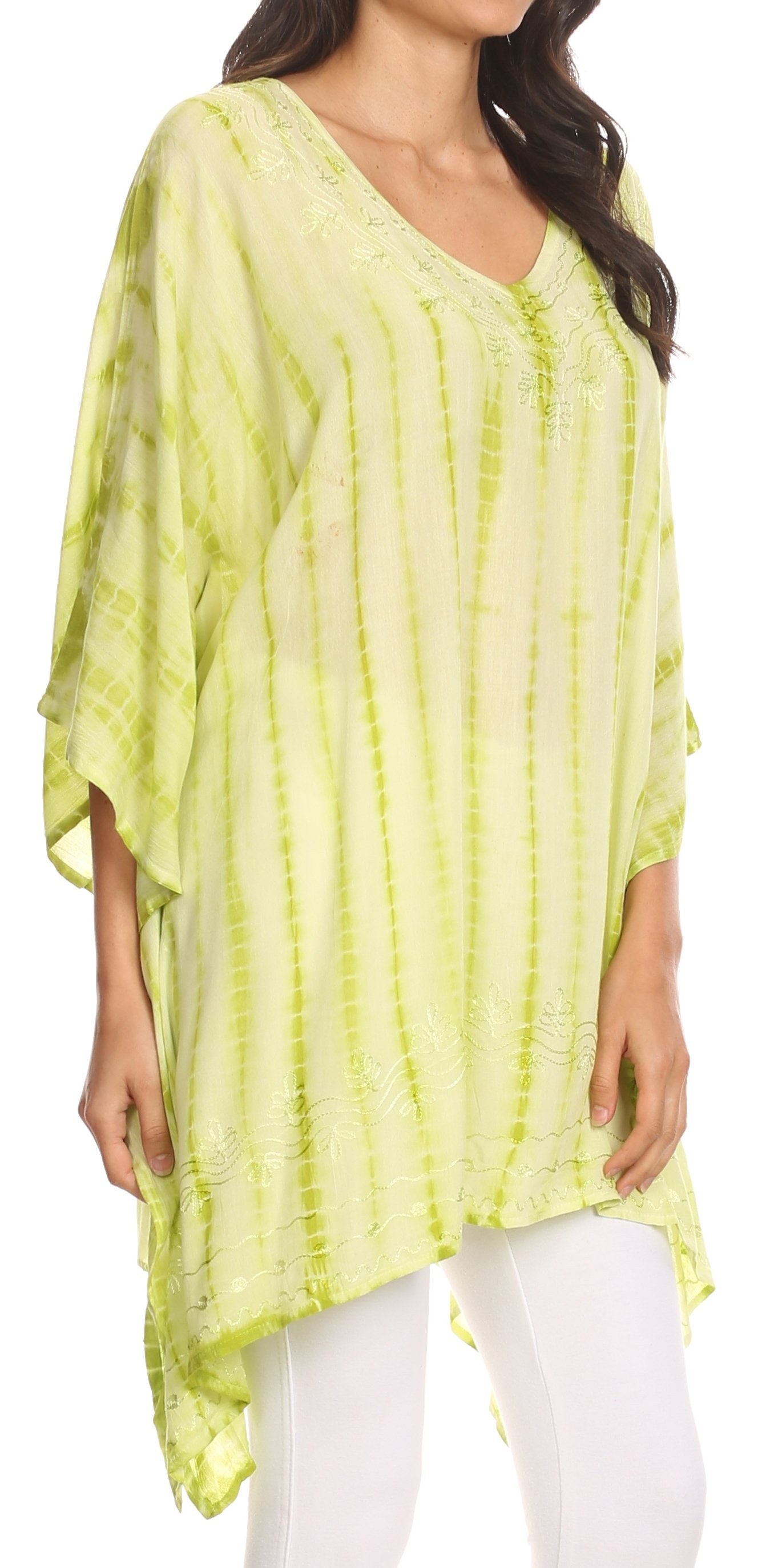 Woman wearing a light green tie-dye shirt with white pants on a white background