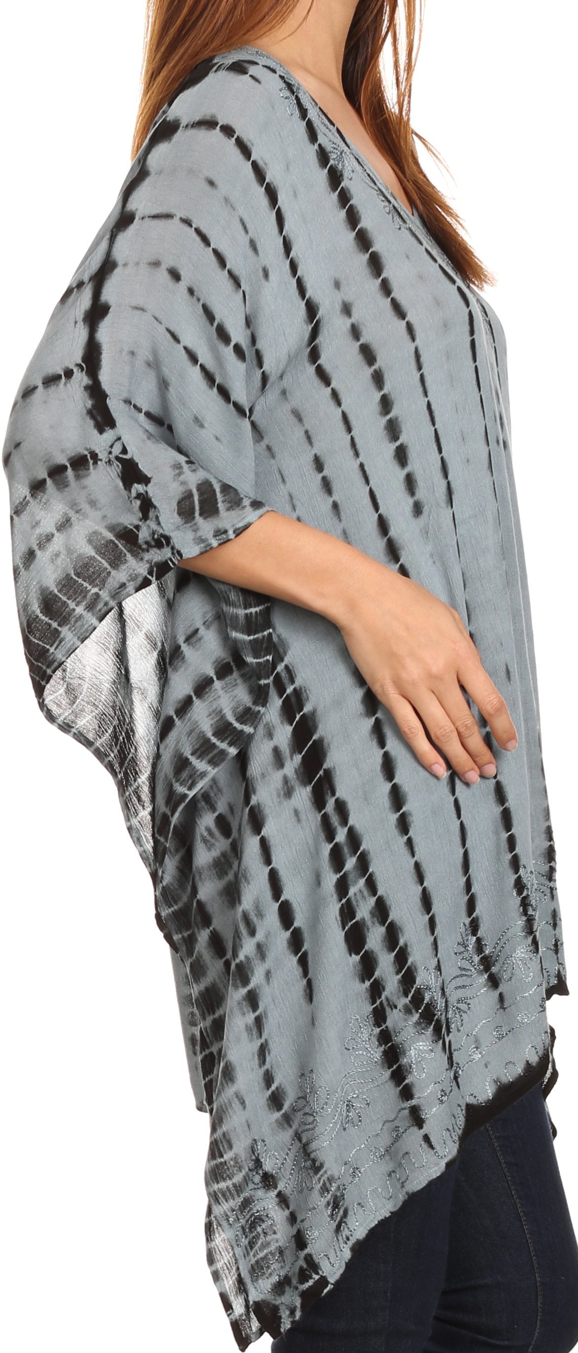 Person wearing a gray tie-dye poncho with a white background