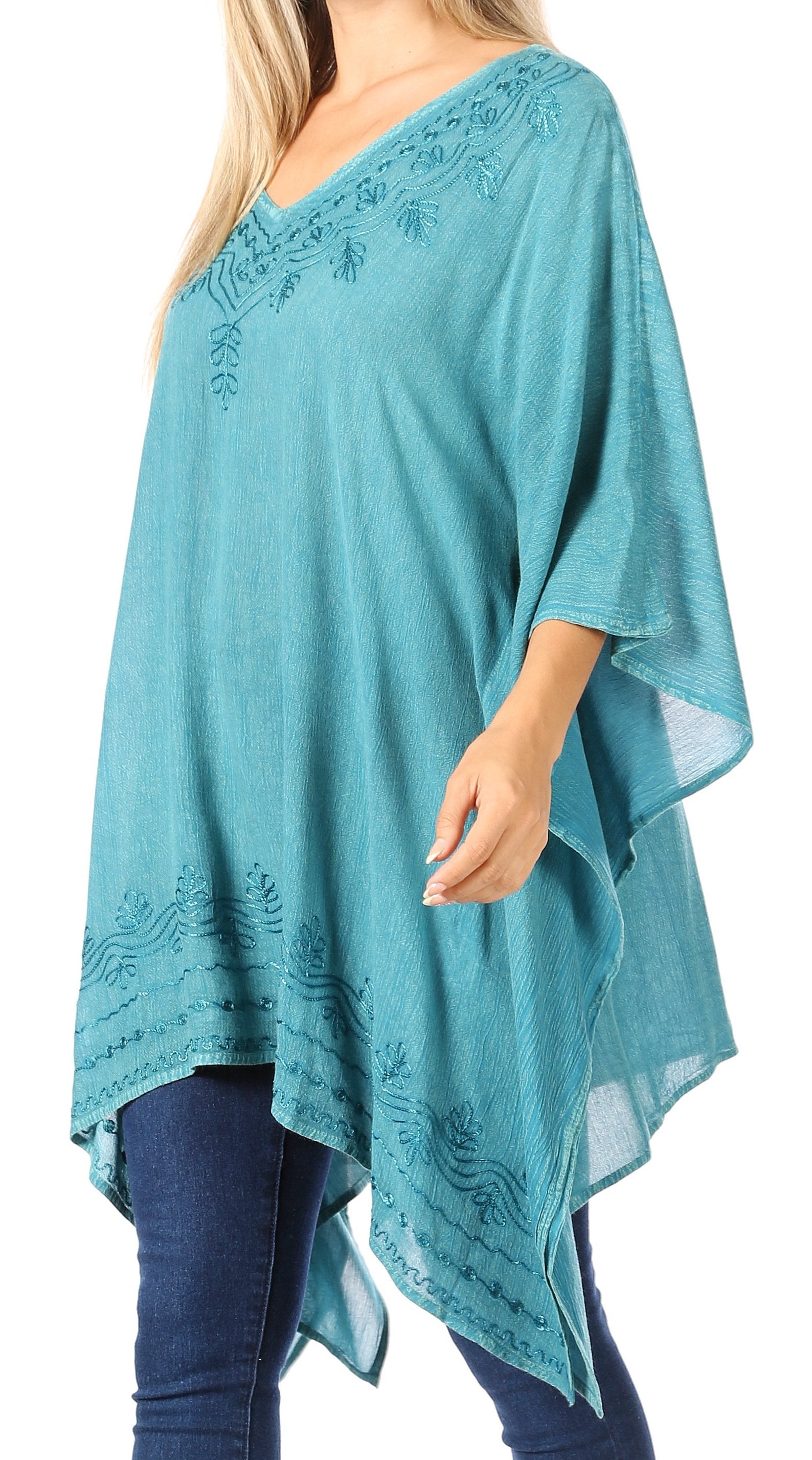 Teal poncho with lace details worn by a person on a white background