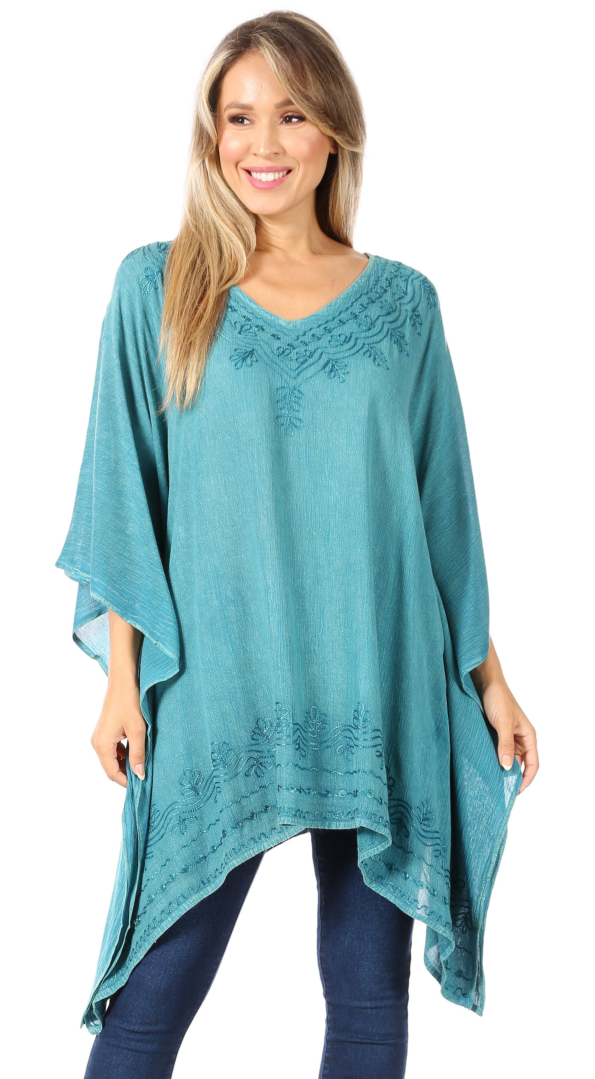 Woman wearing a teal poncho with lace details on a white background