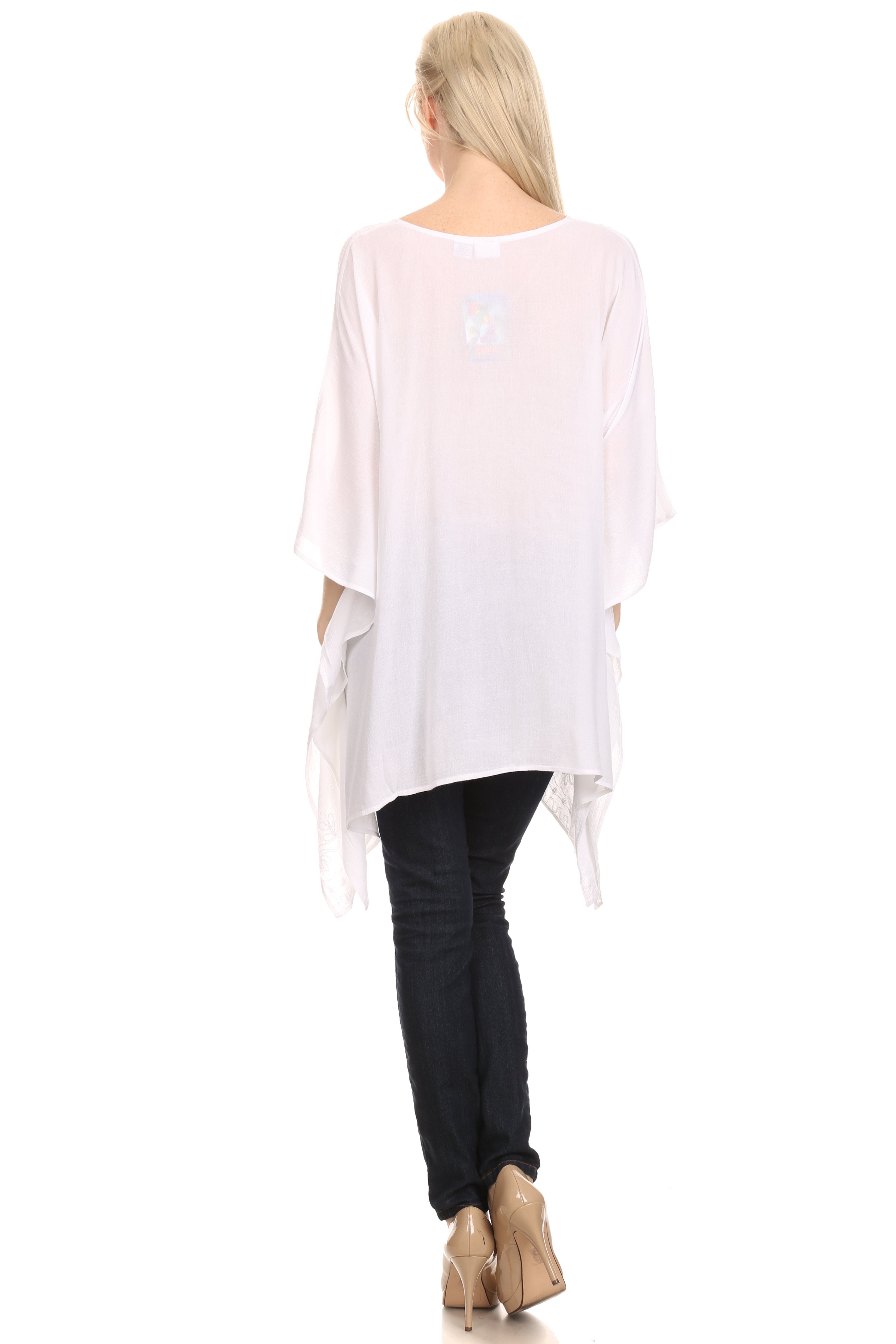 Woman wearing a white oversized shirt and black pants on a white background