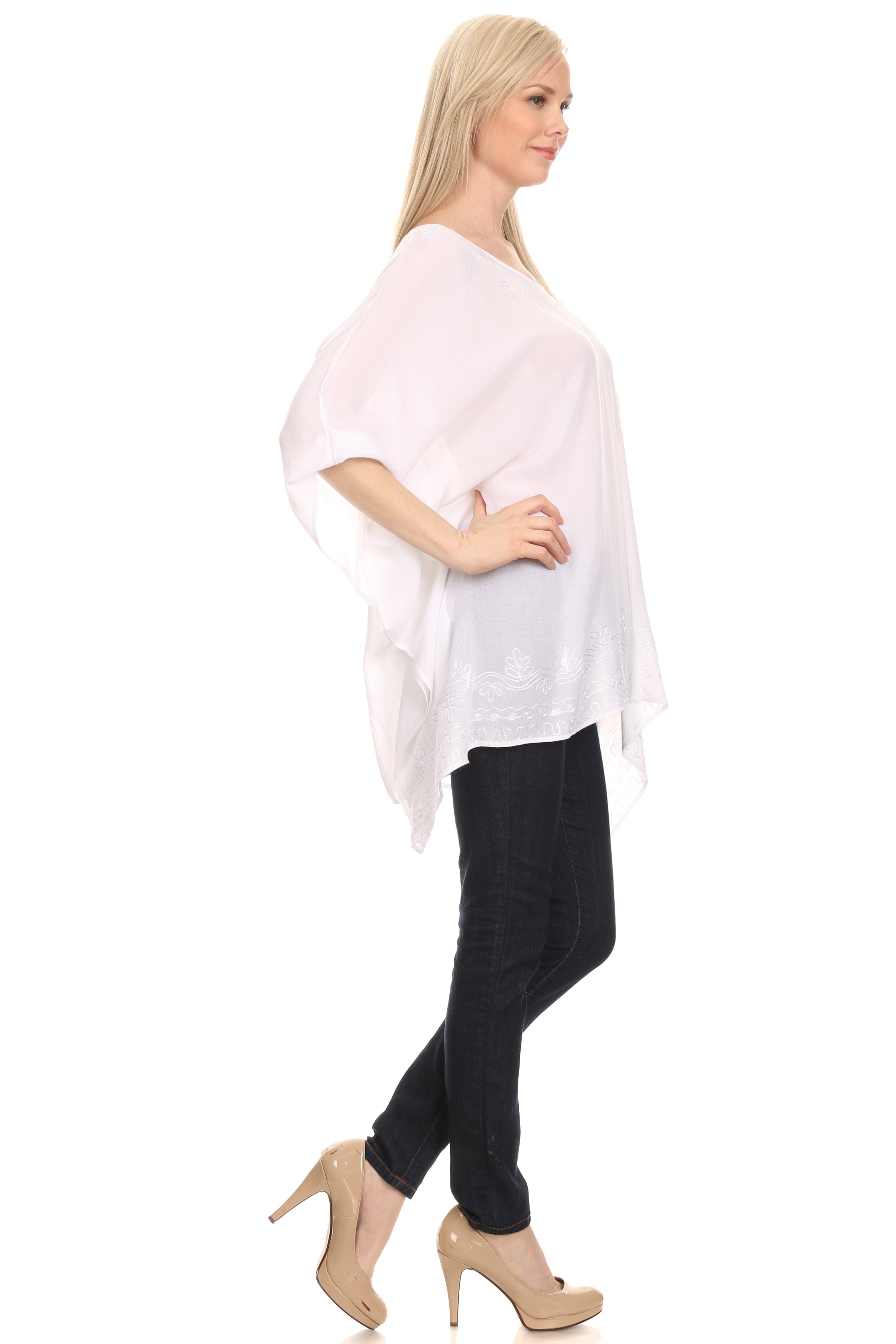 Woman wearing a light pink poncho over a black outfit on a white background