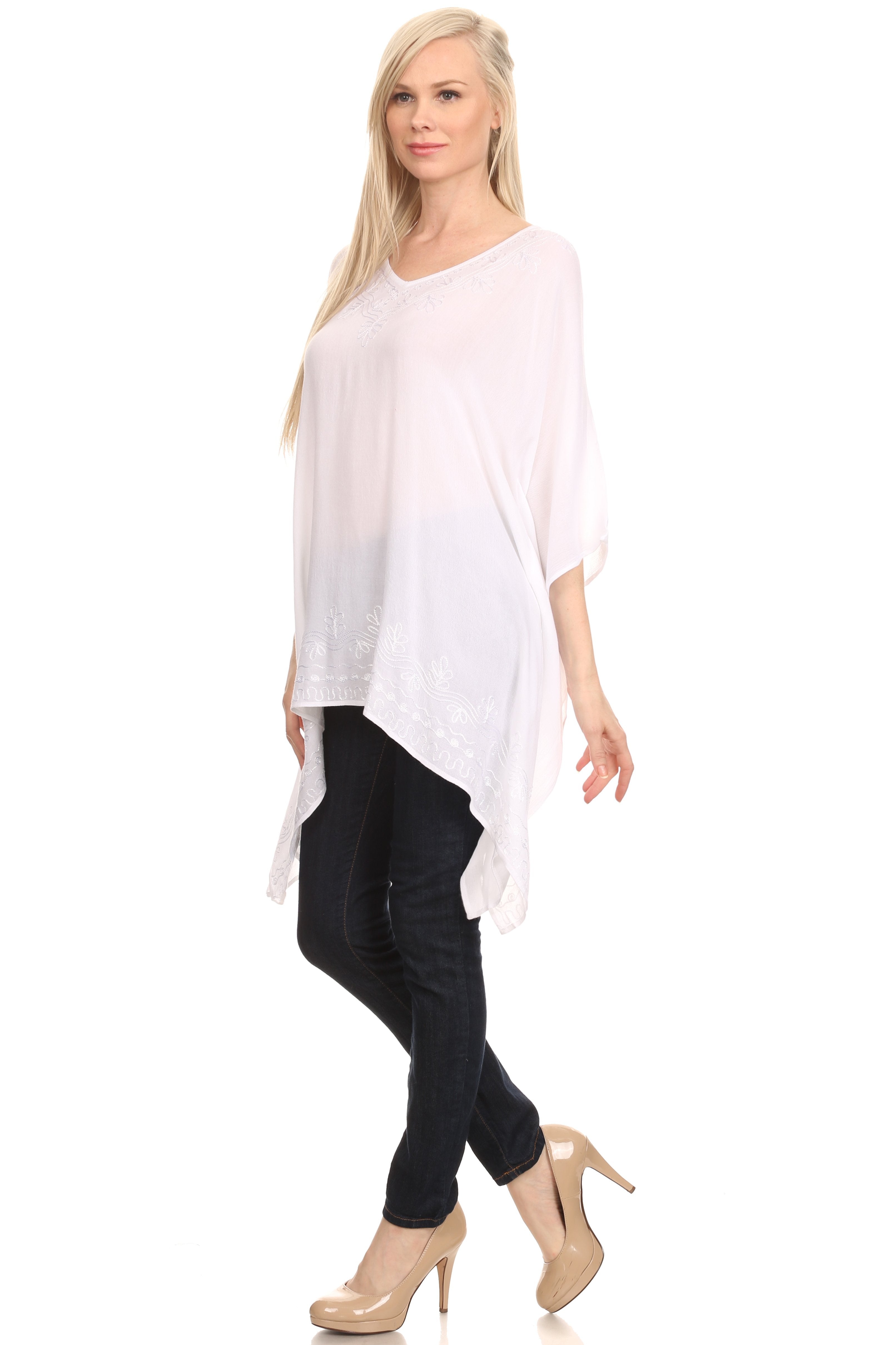 Woman wearing a white oversized top and black pants on a white background