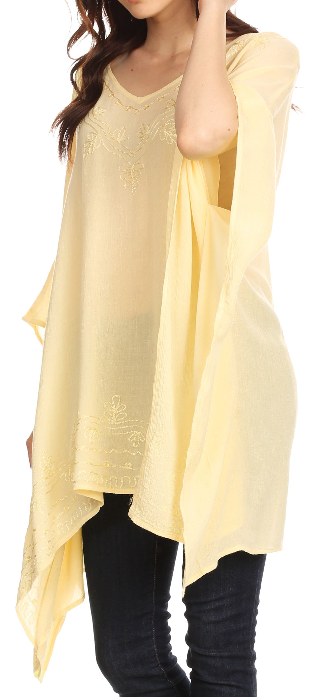 Woman wearing a light yellow oversized top with black pants.