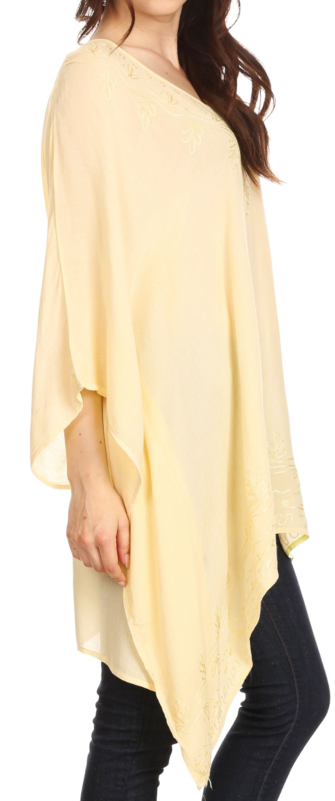 Woman wearing a light yellow poncho over dark pants
