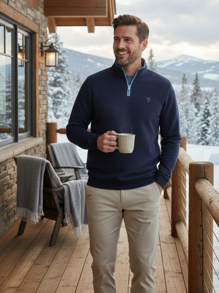 Man holding a mug on a wooden deck with a snowy mountain background