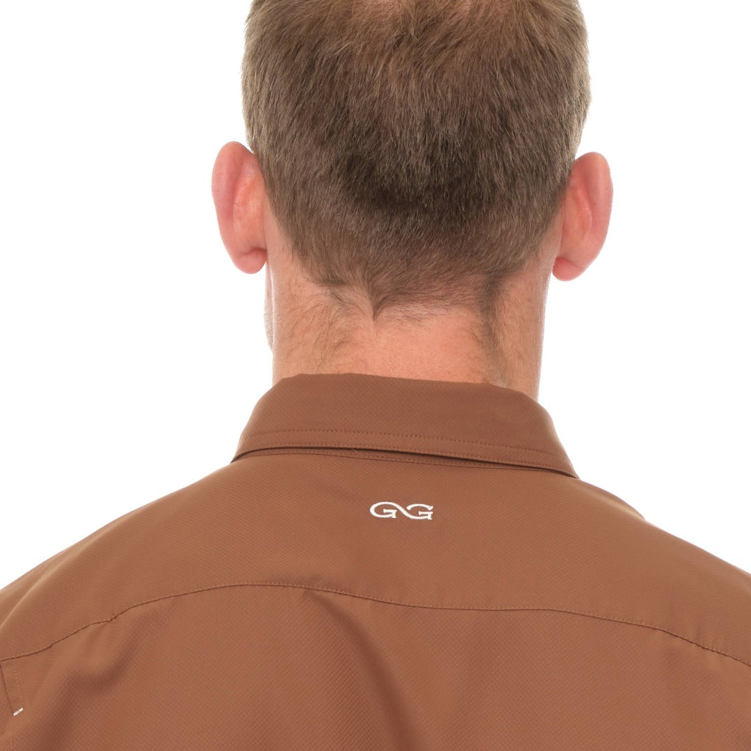 Brown shirt with a logo on the collar against a white background