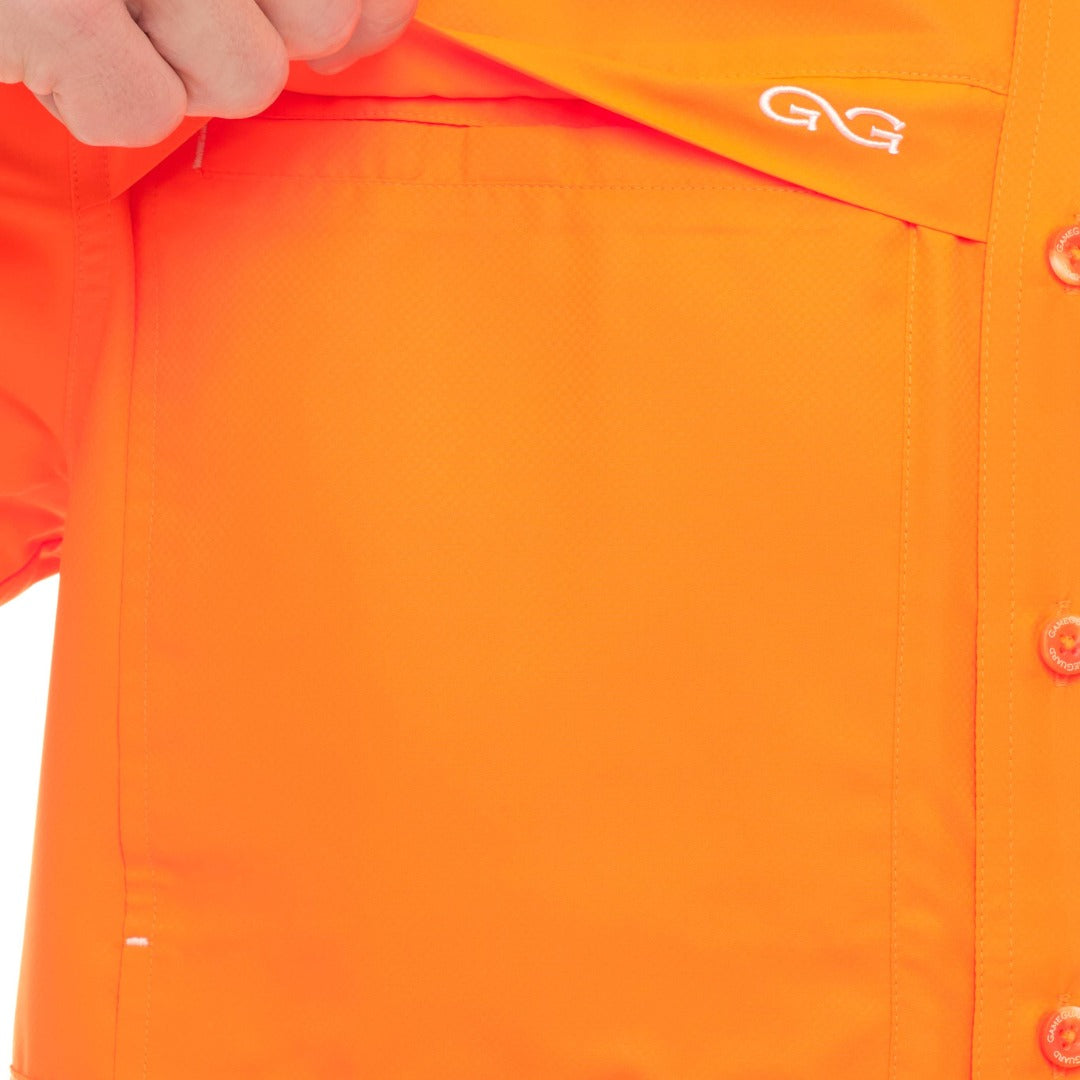 Close-up of an orange shirt with a brand logo on a white background