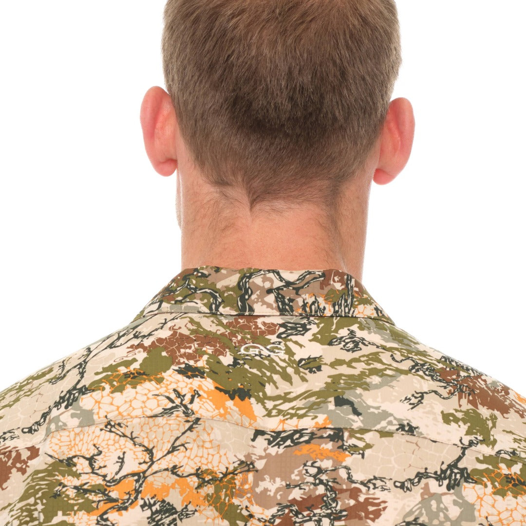 Person wearing a camouflage shirt on a white background