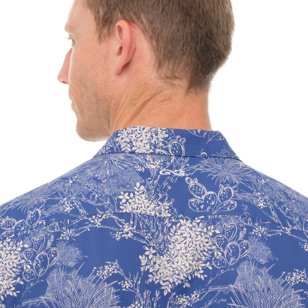 Man wearing a blue floral patterned shirt on a white background