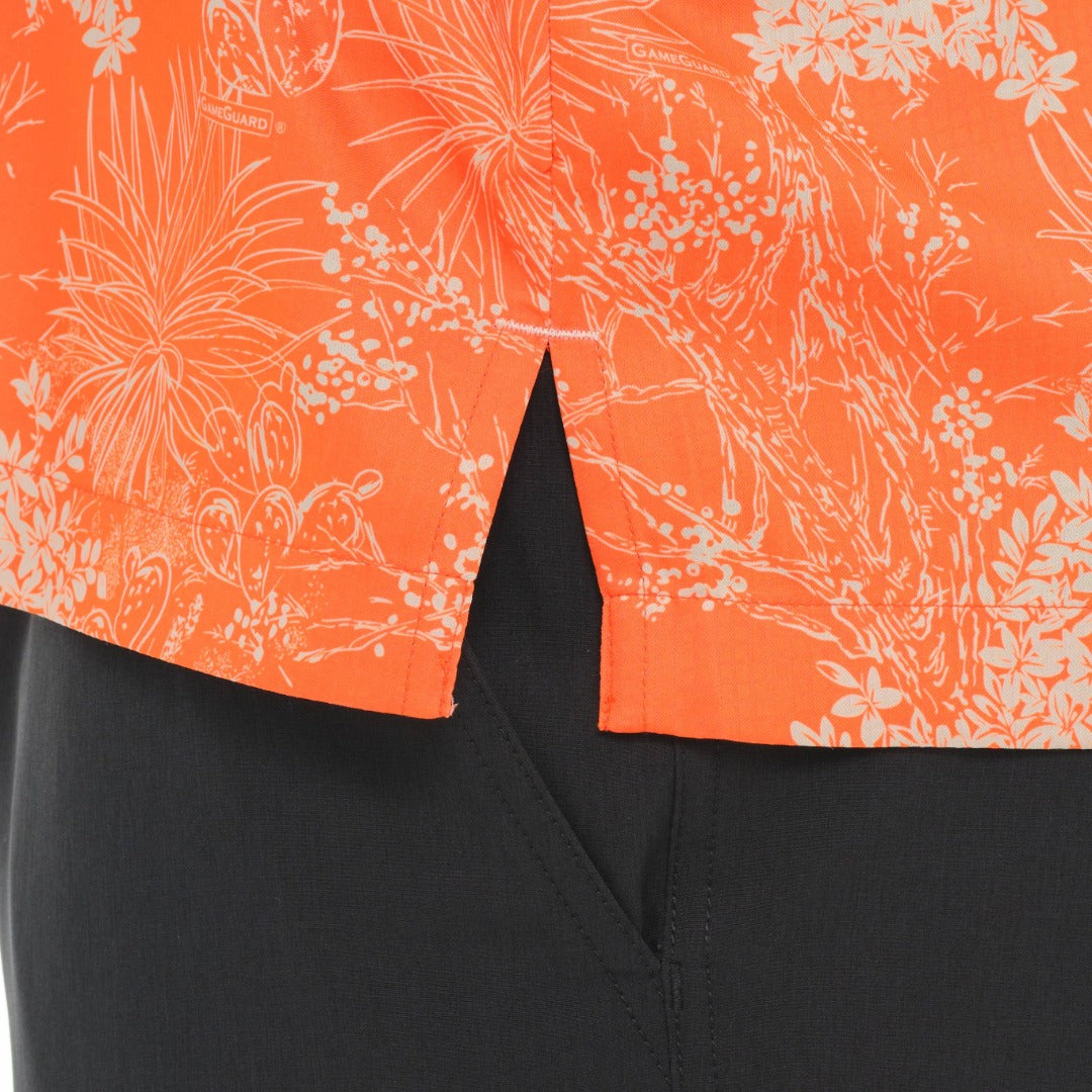 Close-up of an orange floral shirt with a black background
