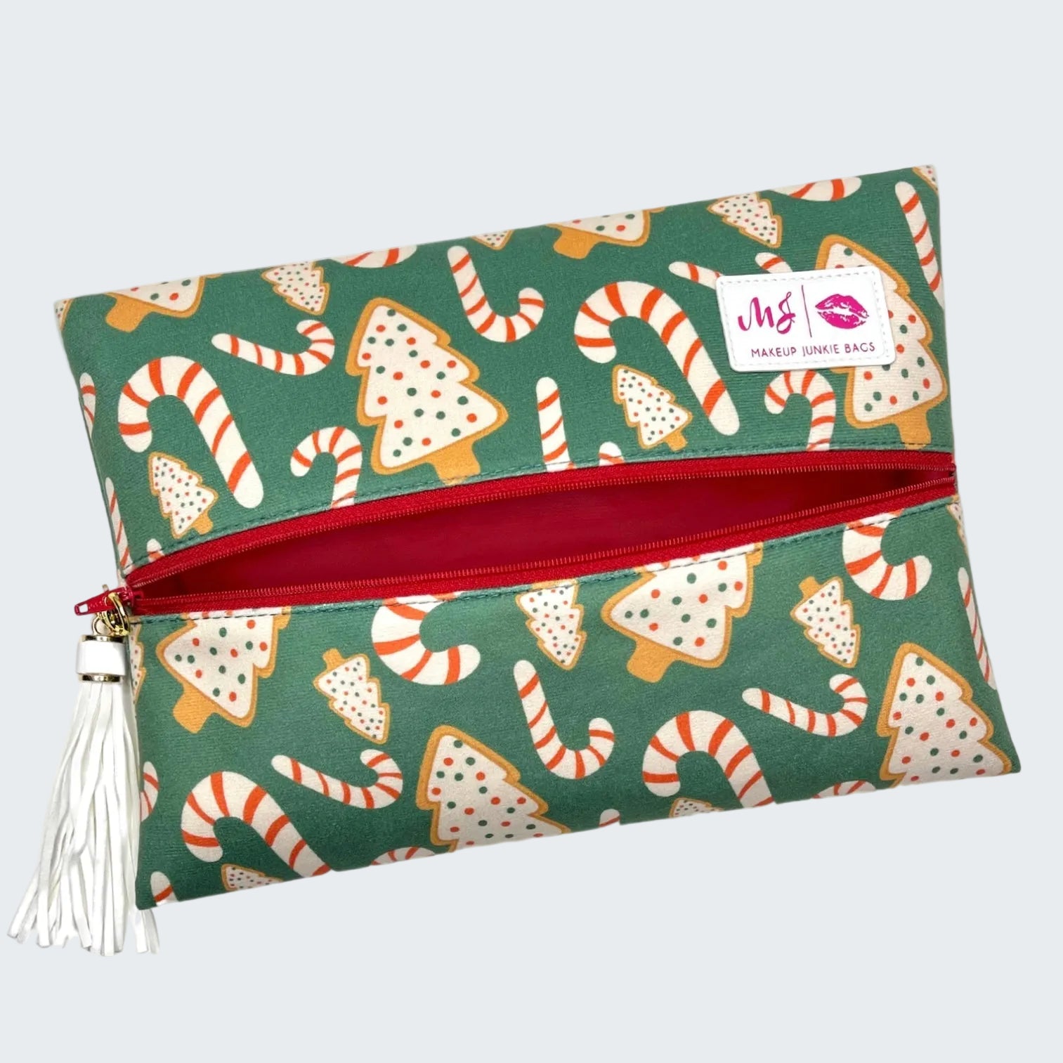 Makeup bag with Christmas-themed design featuring cookies and candy canes on a green background.