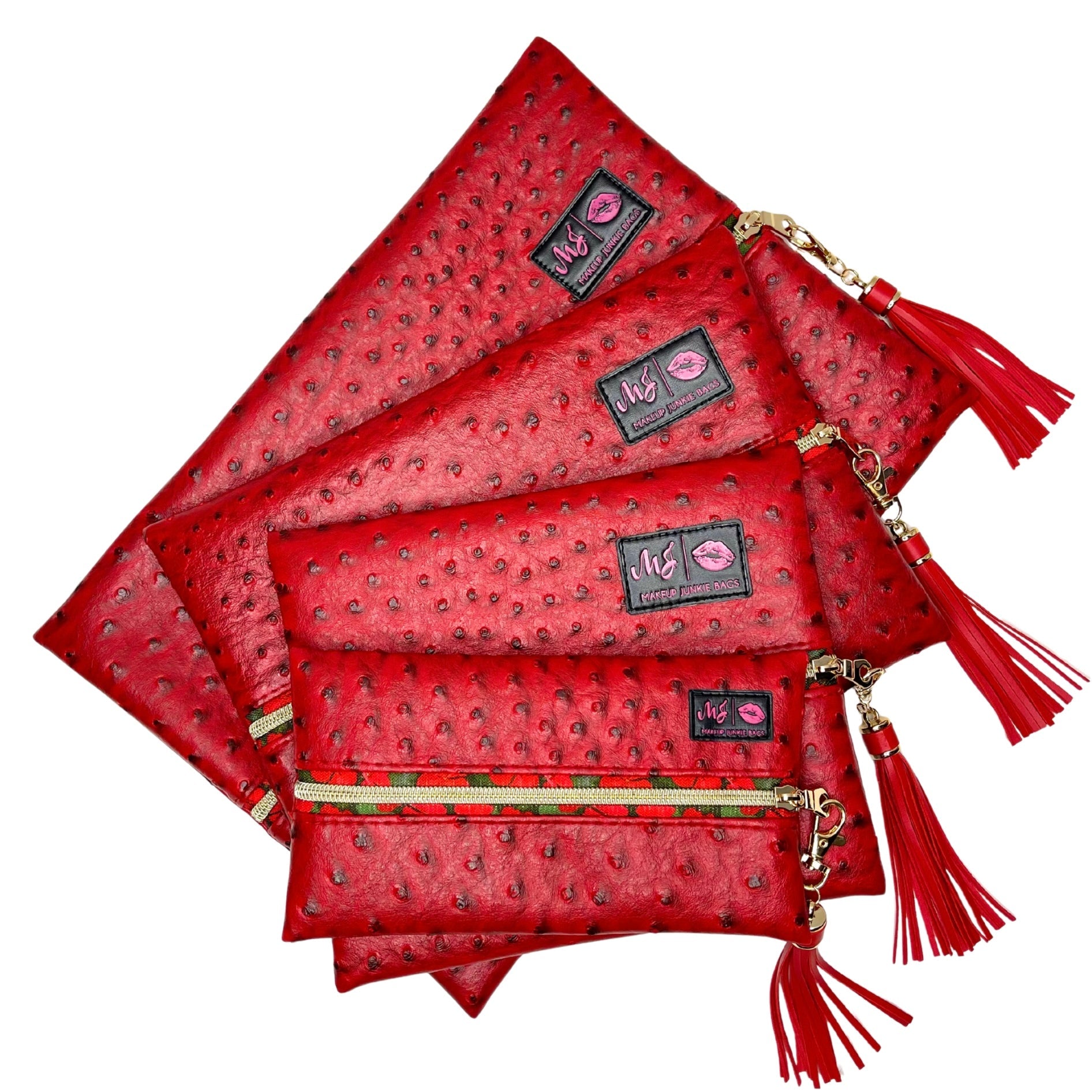 Set of red pouches with gold zippers and tassels on a white background