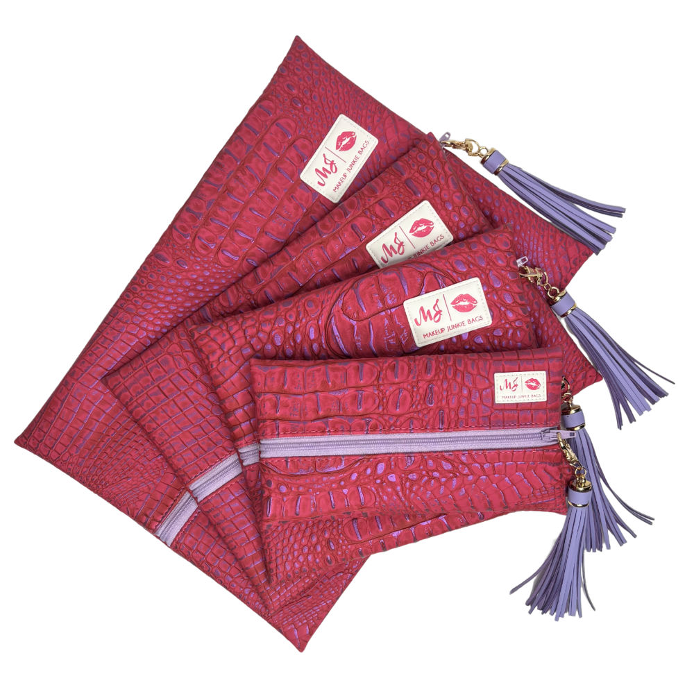 Set of red patterned pouches with purple tassels and visible brand logo on a white background