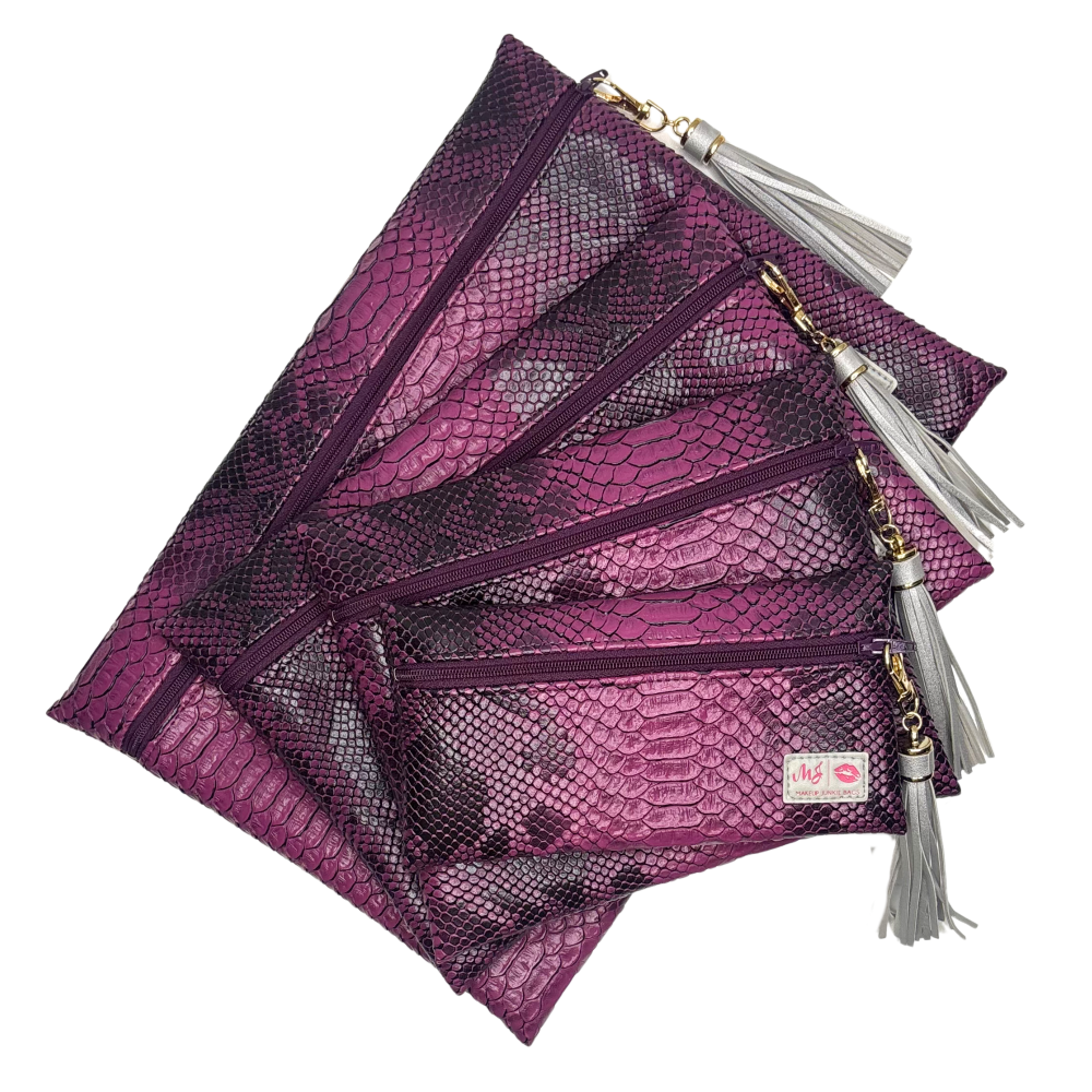 Set of purple makeup bags with tassels on a white background