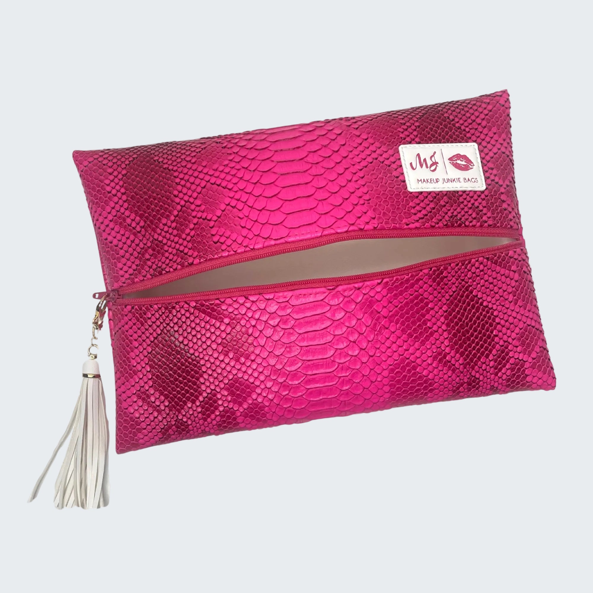 Pink textured clutch bag with a tassel on a white background